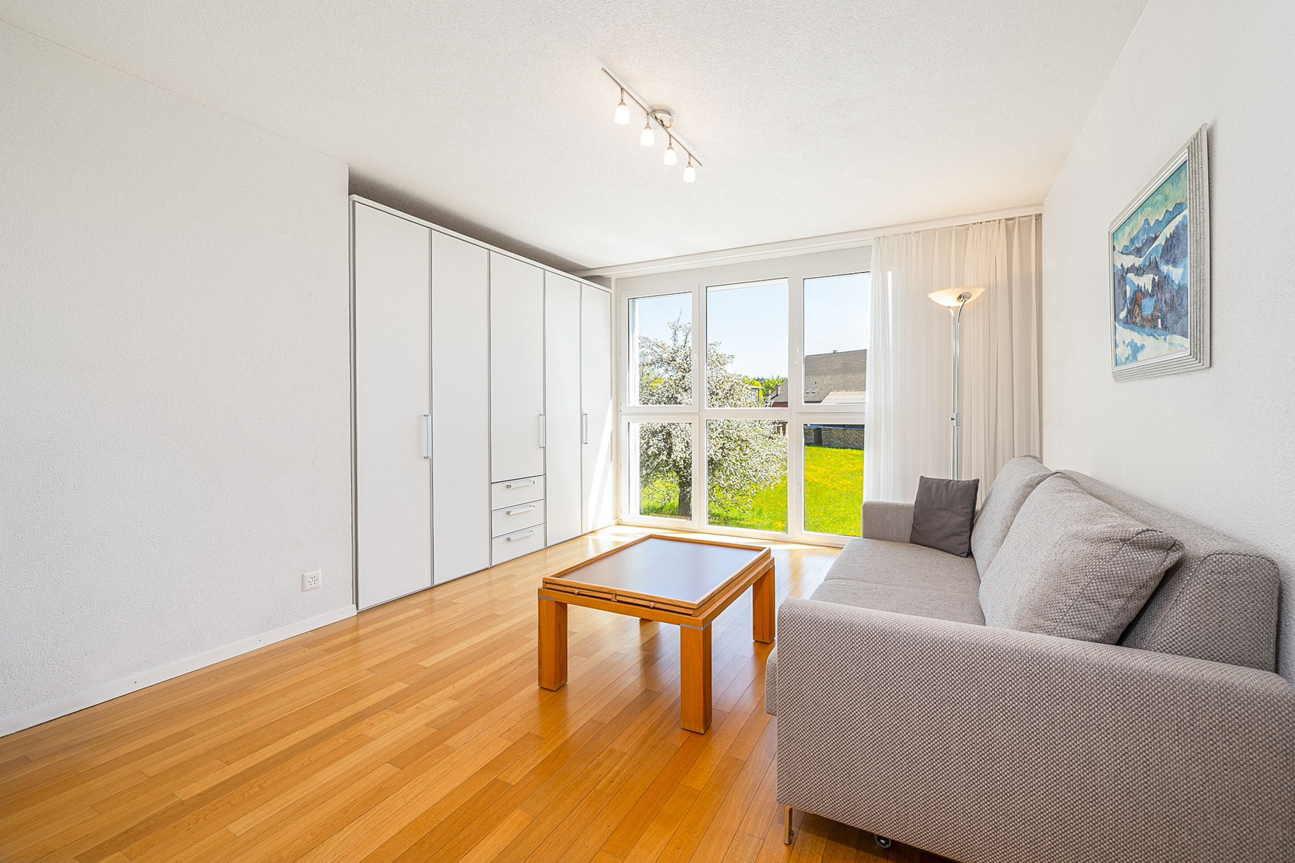 Helles Wohnzimmer mit Sofa und Fensterfront