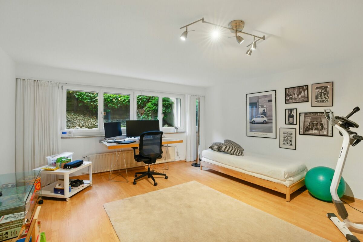 Helles Arbeits- und Schlafzimmer mit Bett und Schreibtisch