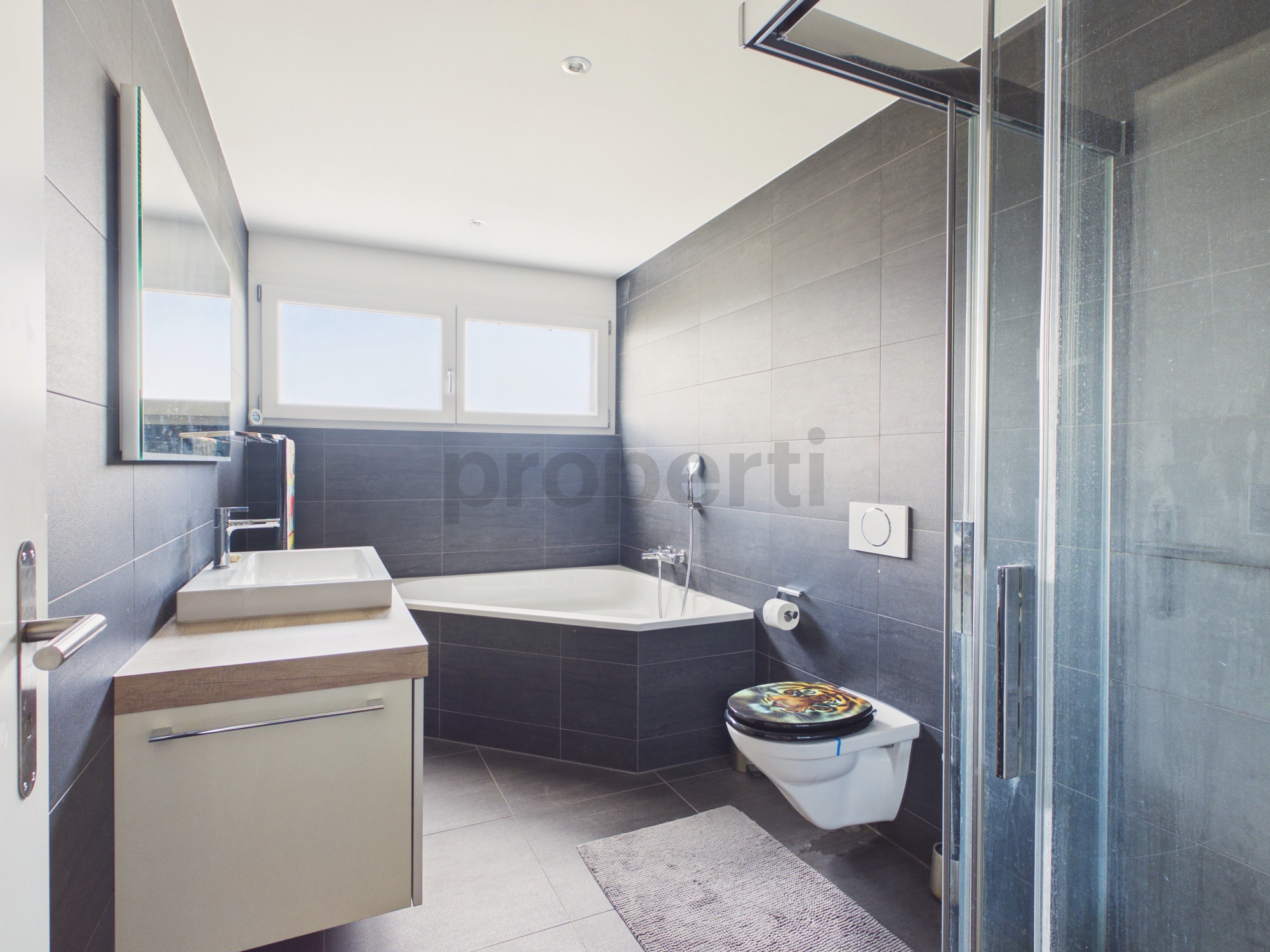 Modernes Badezimmer mit Badewanne, Dusche und WC