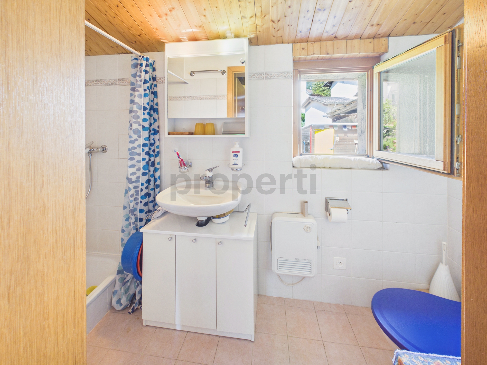 Kleines Badezimmer mit Dachfenster und Holzdecke