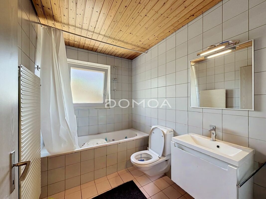 Innenansicht eines kleinen Badezimmers mit Badewanne, WC und Waschbecken
