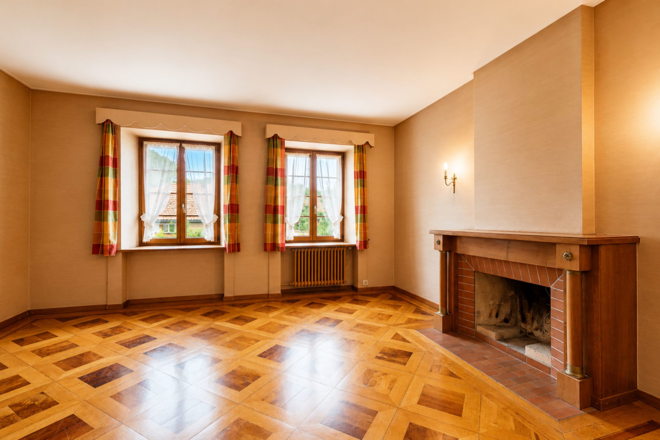 Wohnraum mit Kamin und zwei Fenstern