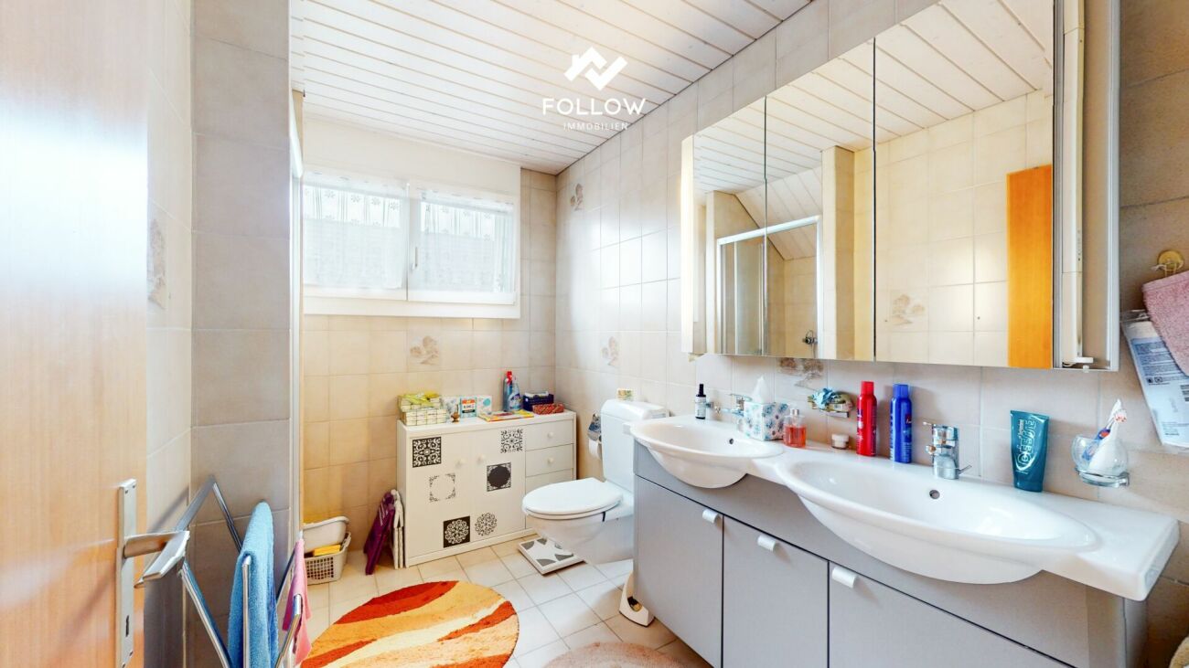 Helles, älteres Badezimmer mit Doppelwaschtisch und Badewanne