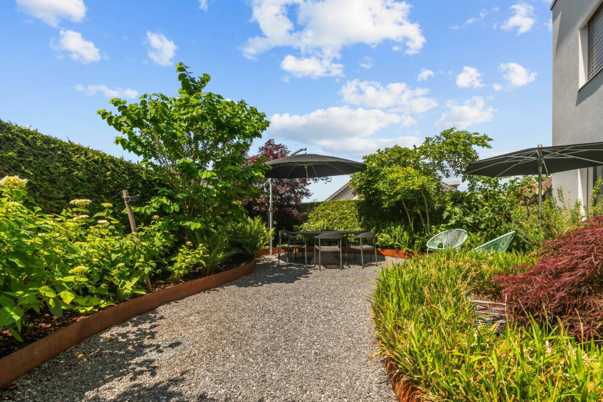 Garten mit Sitzbereich und Sonnenschirmen