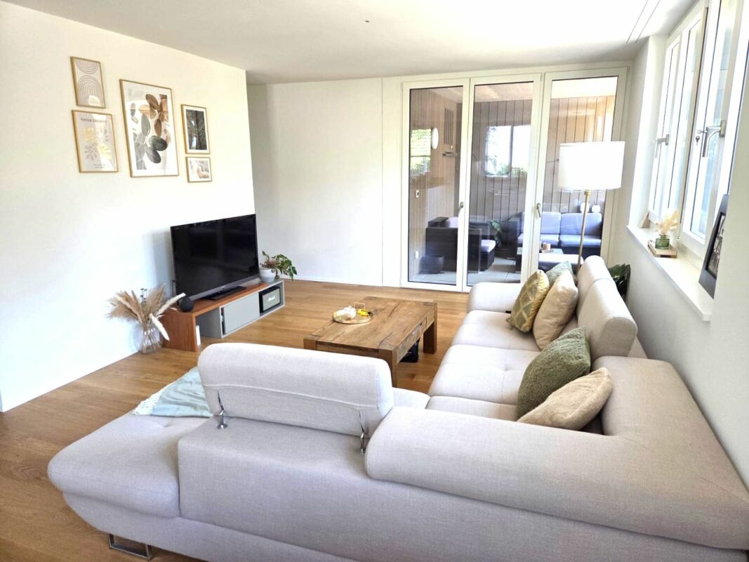 Heller Wohnraum mit großem Sofa und TV
