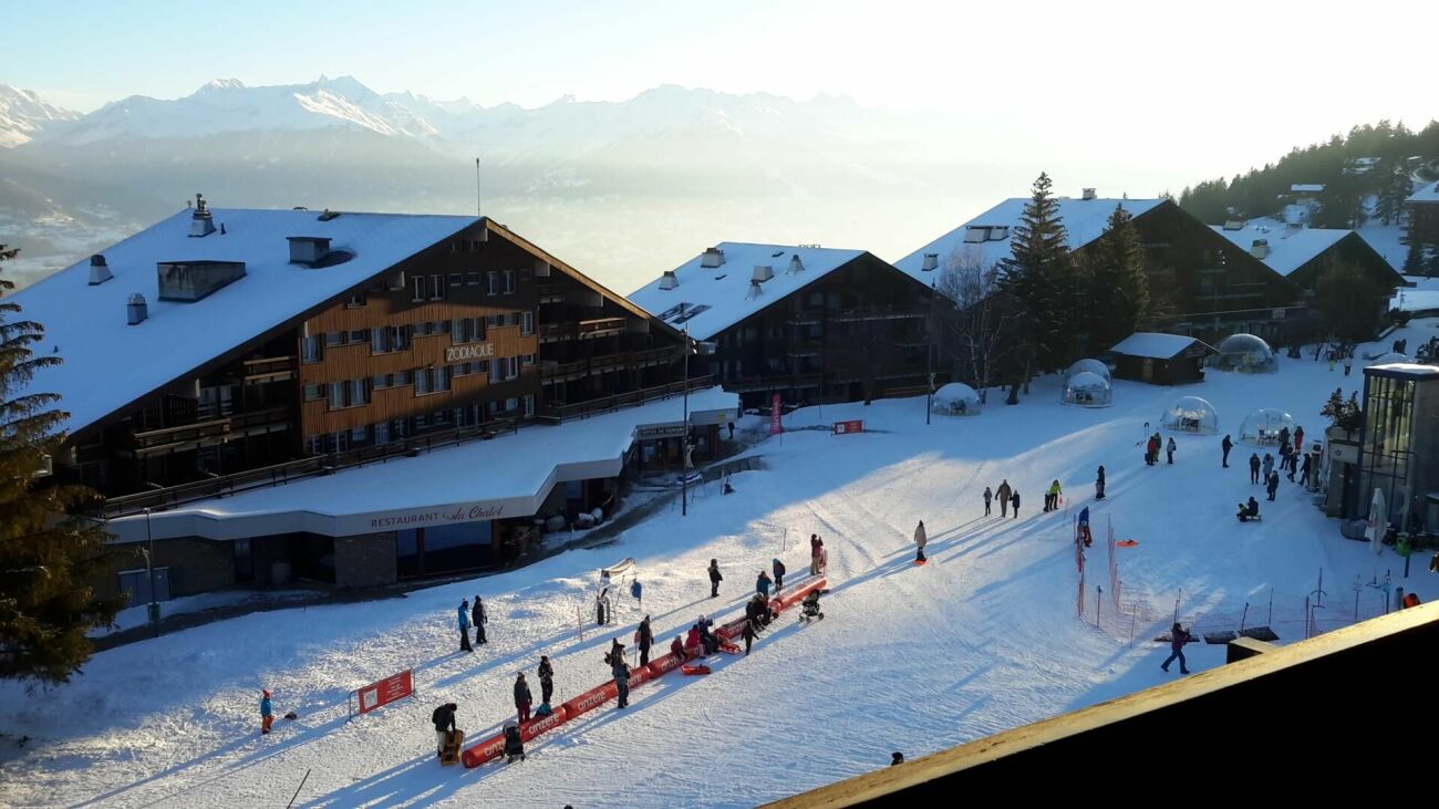 Schneebedecktes Alpen-Resort mit Skifahrern