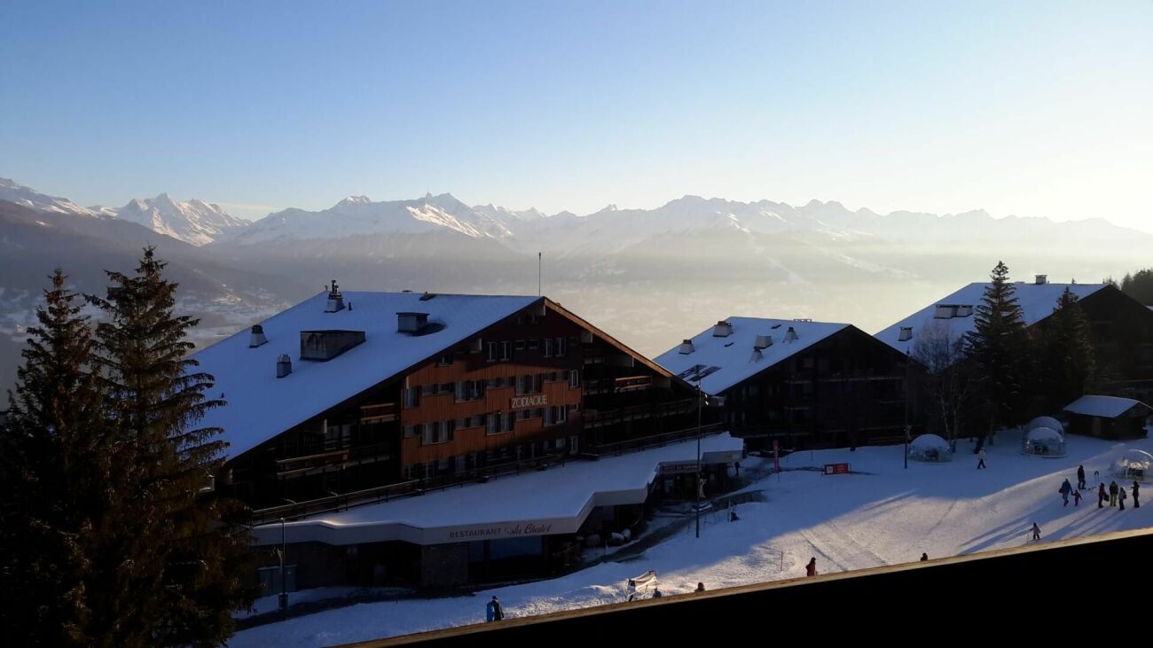 Schneebedecktes Alpenresort mit Bergpanorama