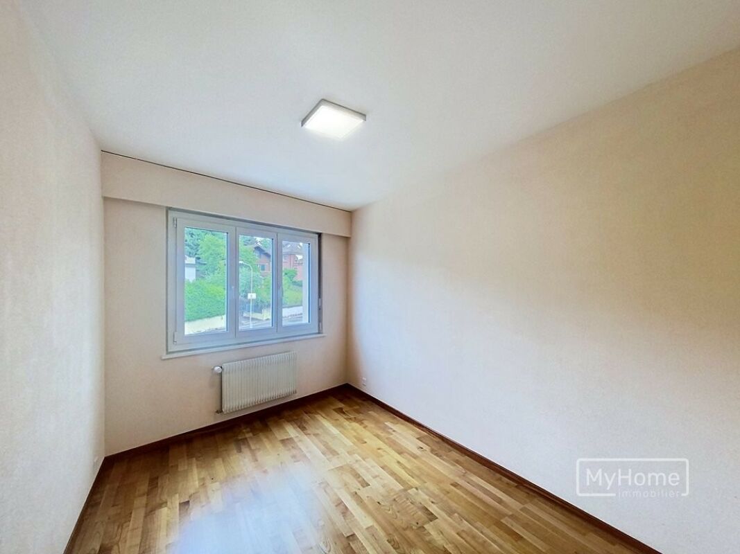 Helles, leerstehendes Zimmer mit Fenster und Heizkörper