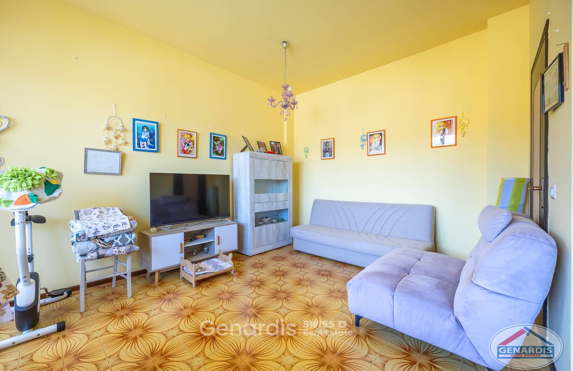 Wohnzimmer mit bunten Wandbildern und Sofas