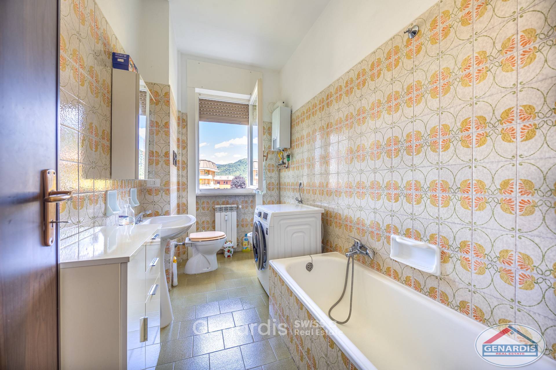 Badezimmer mit Waschmaschine und Badewanne