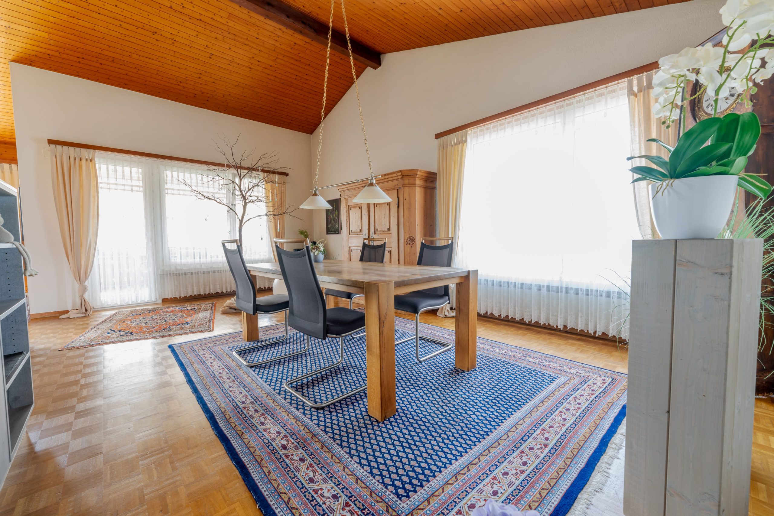Heller Essbereich mit Holzdach und großem Teppich