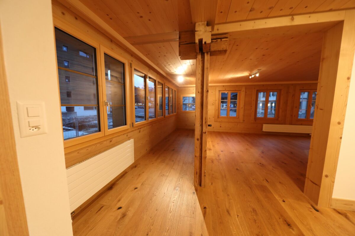 Holzvertäfelter Wohnraum mit großen Fenstern