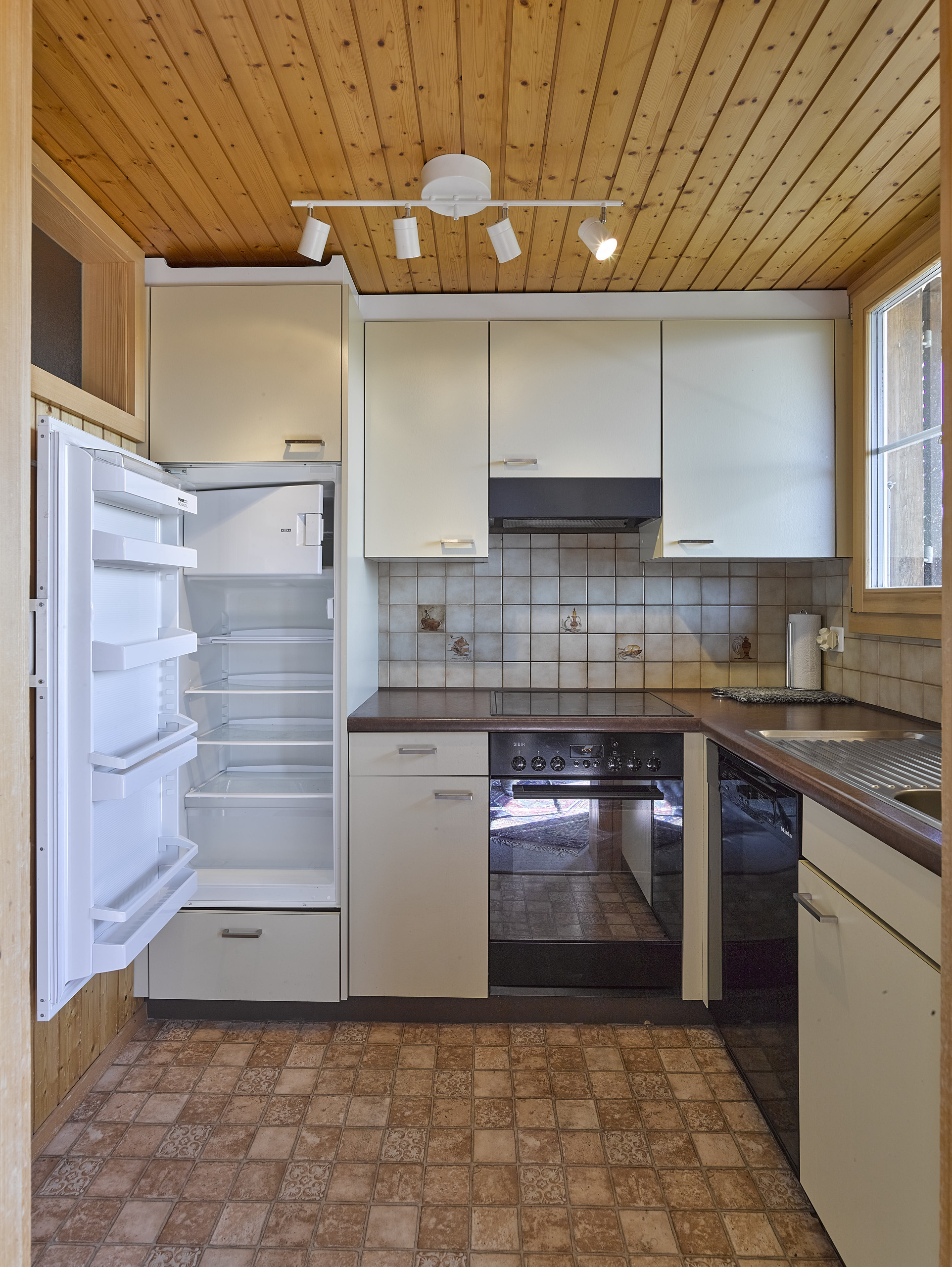 Kleine Küche mit Holzdecke und hellen Fronten