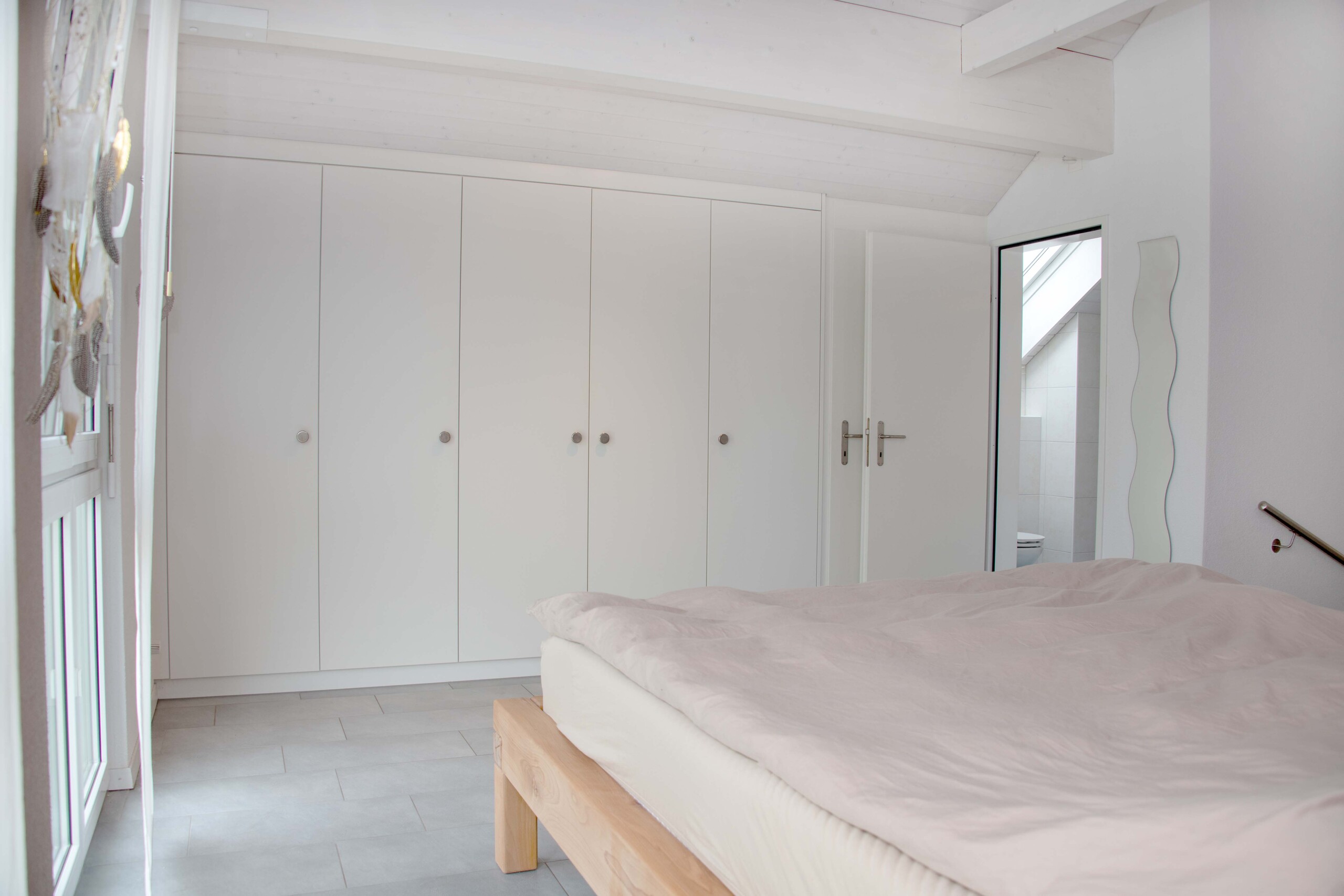 Helles Schlafzimmer mit Einbauschrank und Dachschräge