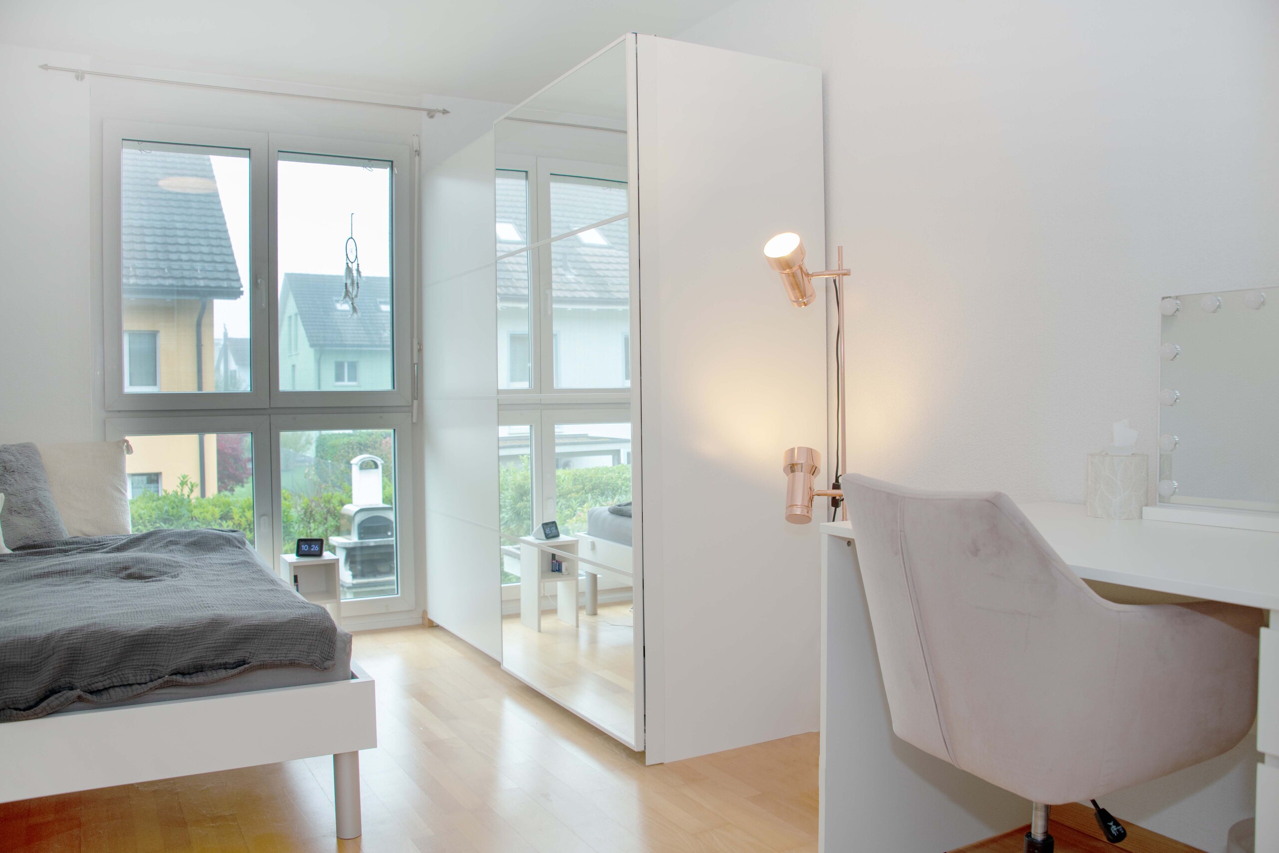 Helles Schlafzimmer mit Fensterfront und Schreibtisch