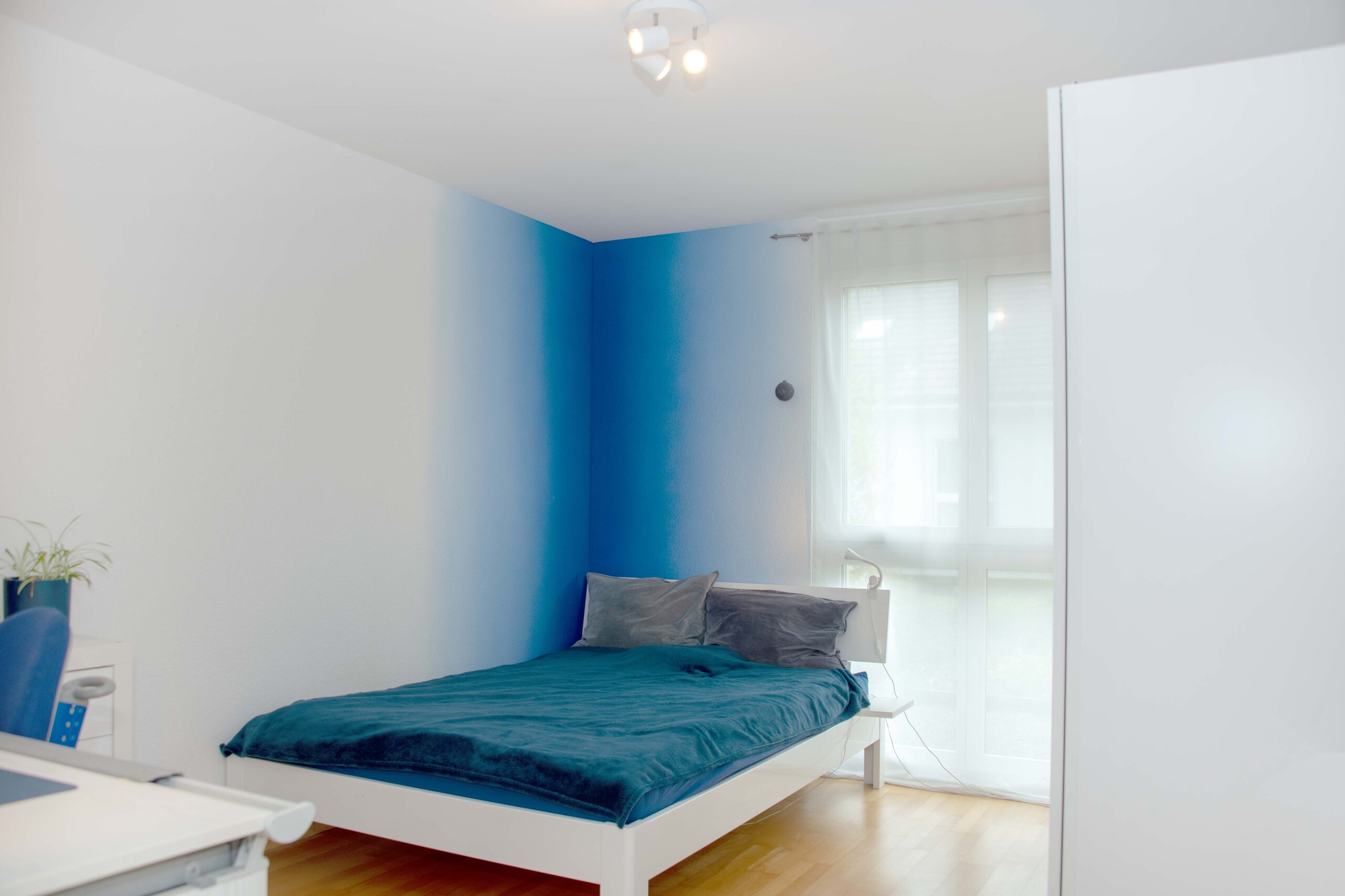 Helles Schlafzimmer mit blauem Akzent