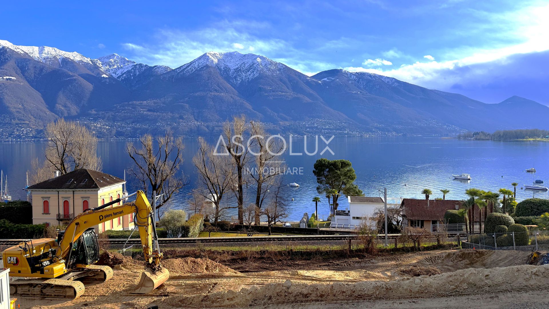 Seeblick mit Bergpanorama und Baustelle am Ufer