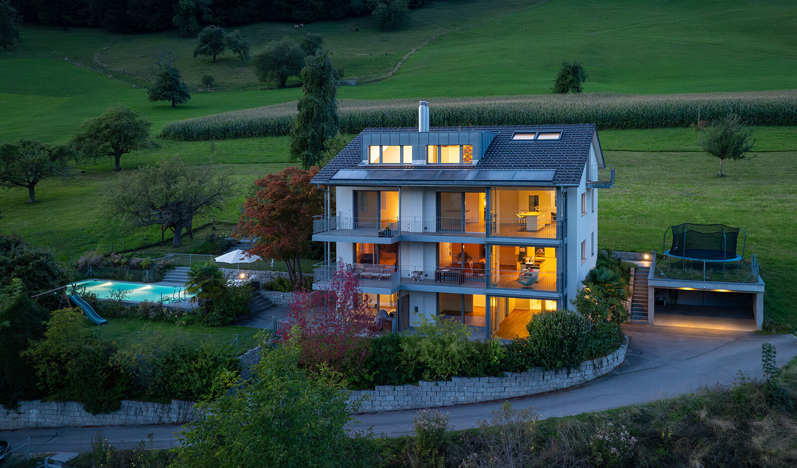 Villa in Hanglage mit Pool und Garten bei Dämmerung