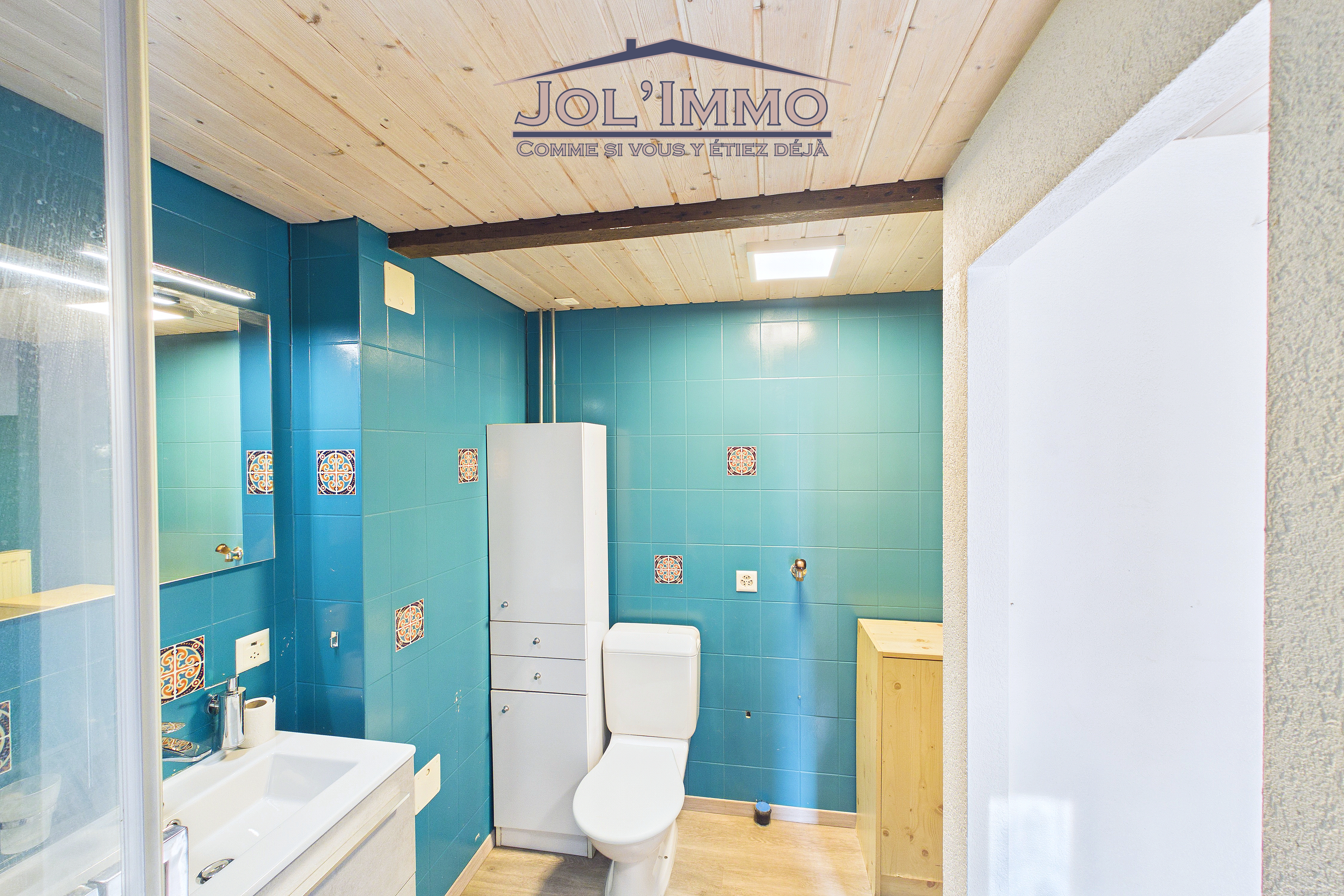 Gäste-WC mit farbigen Fliesen und Holzdecke