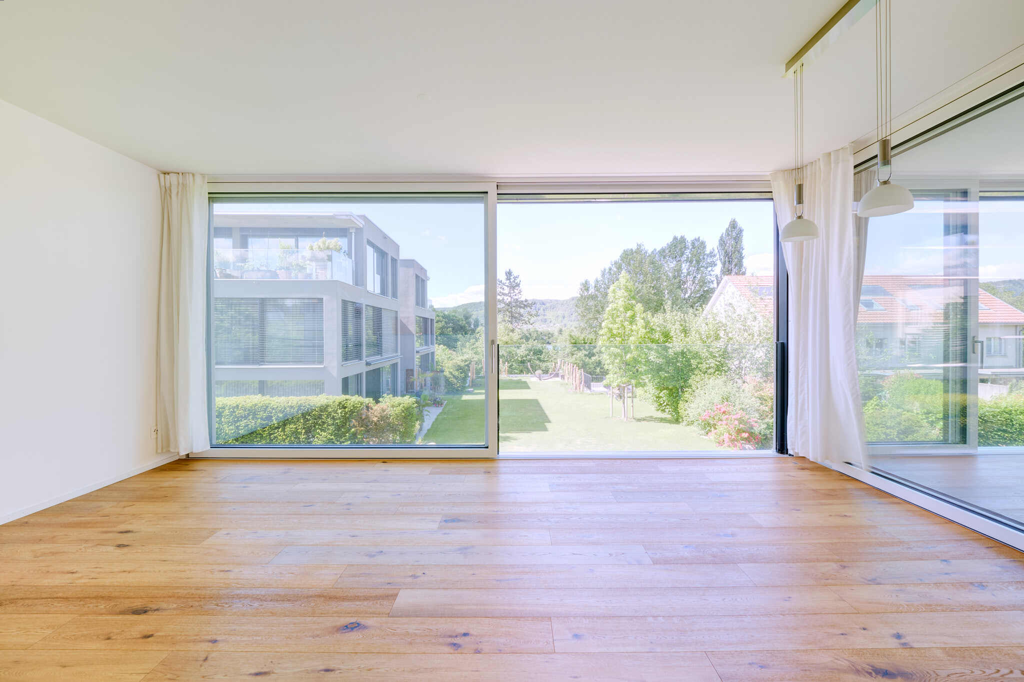 Heller Wohnraum mit Panoramafenster und Gartenblick