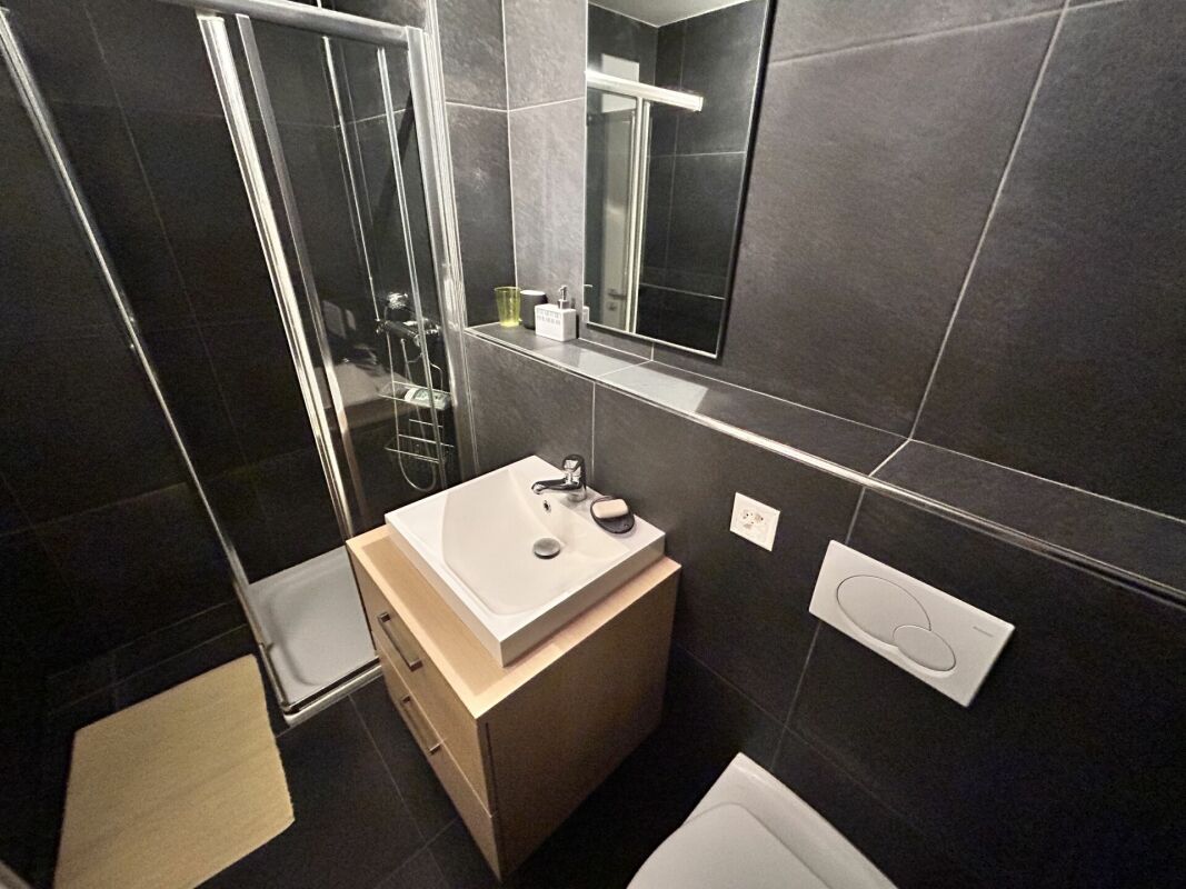 Modernes dunkles Badezimmer mit Glasdusche