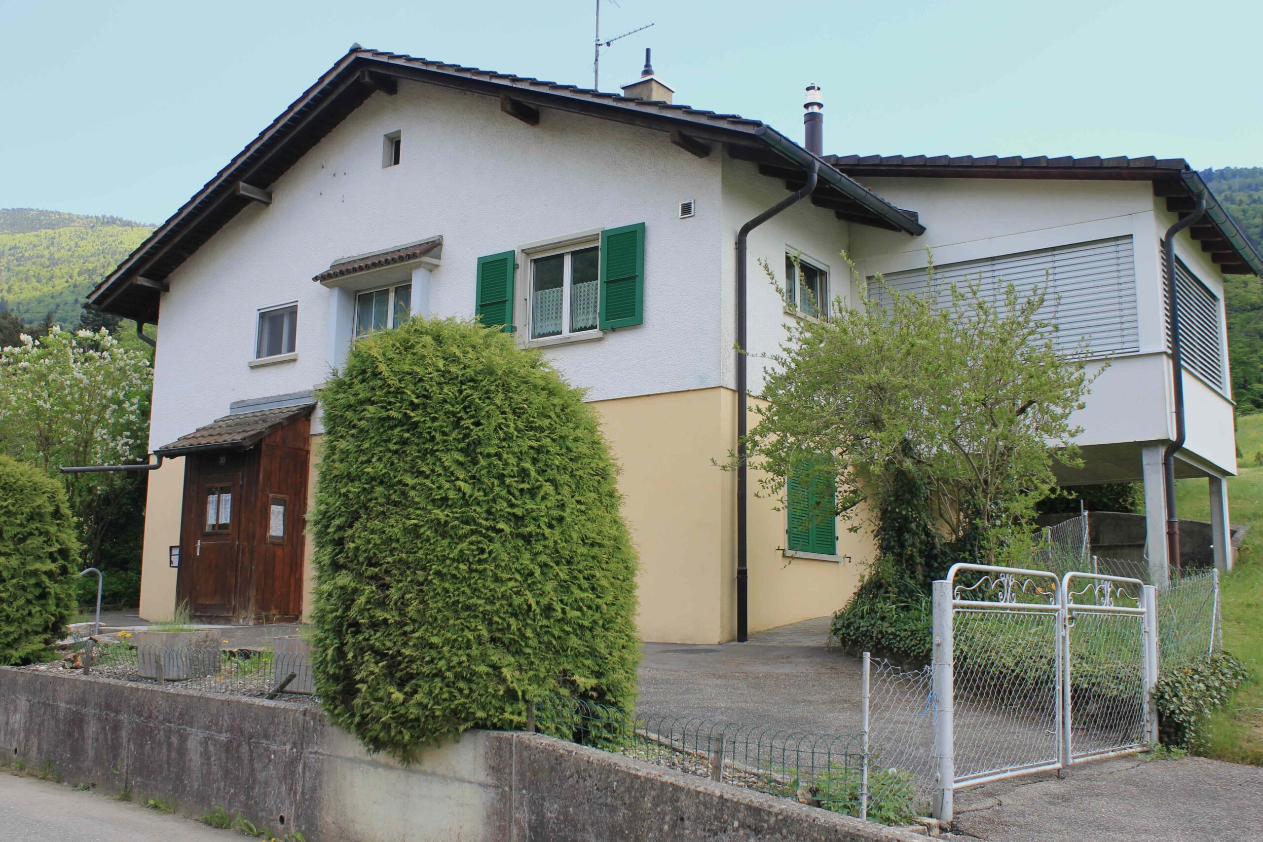 Einfamilienhaus mit Walmdach und Gartenansicht