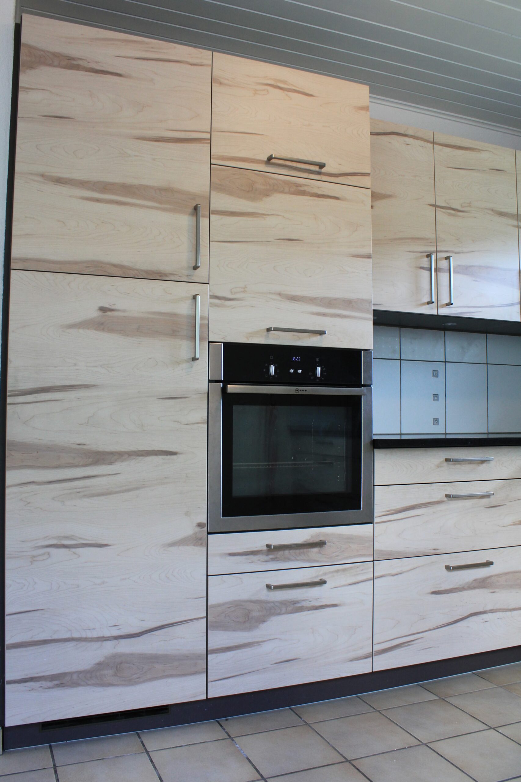 Moderne Einbauküche mit Holzfronten und integriertem Backofen