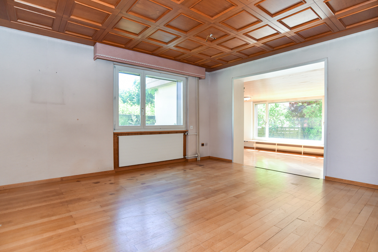 Leeres Wohnzimmer mit Holzboden und Kassettendecke