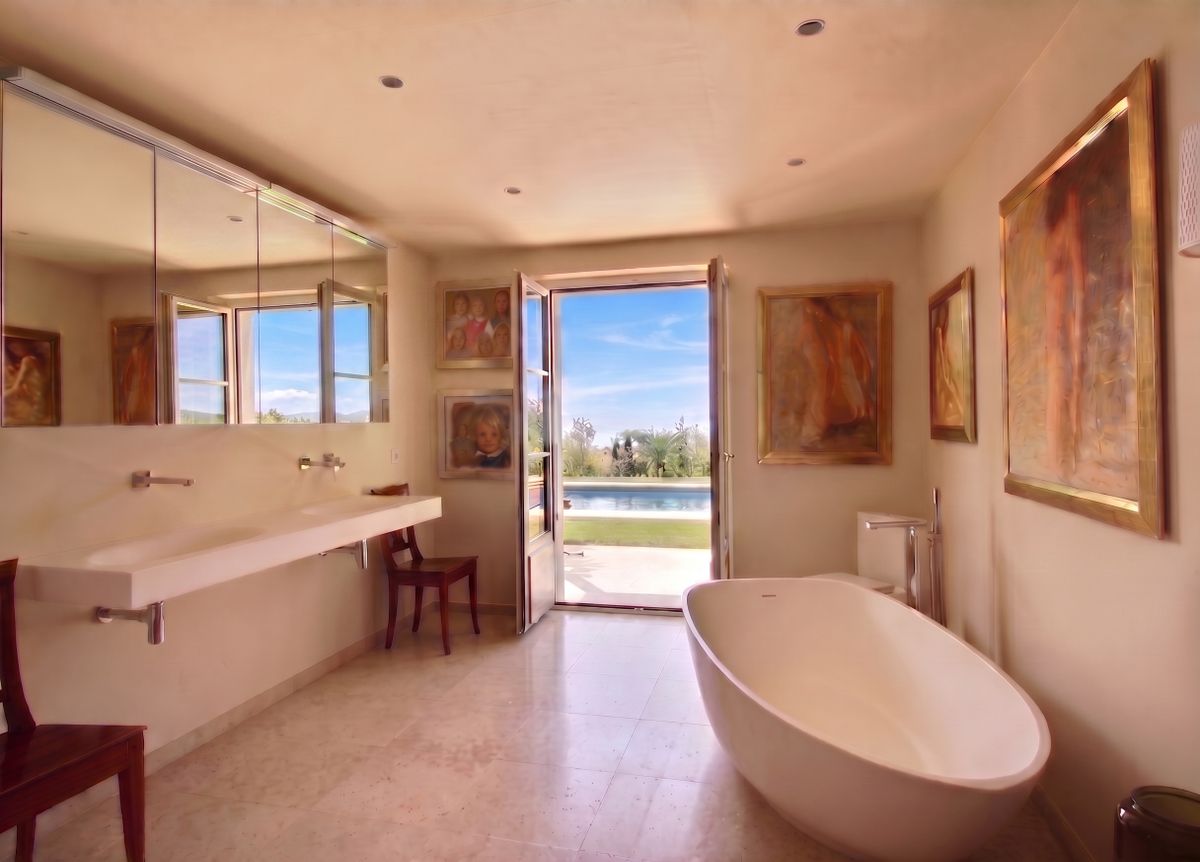 Modernes Badezimmer mit freistehender Badewanne und Poolblick