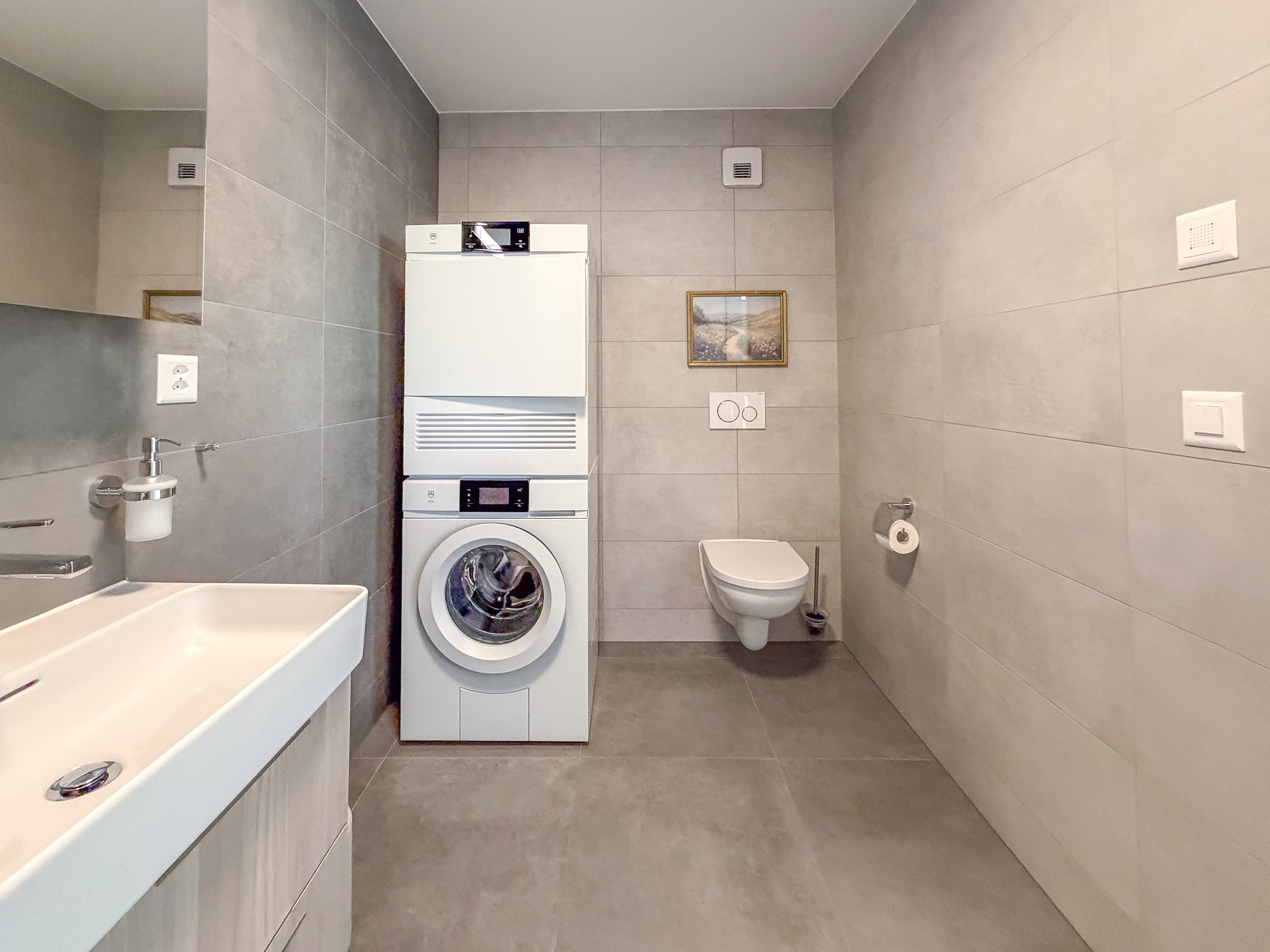 Modernes Badezimmer mit Waschmaschine und wandhängendem WC