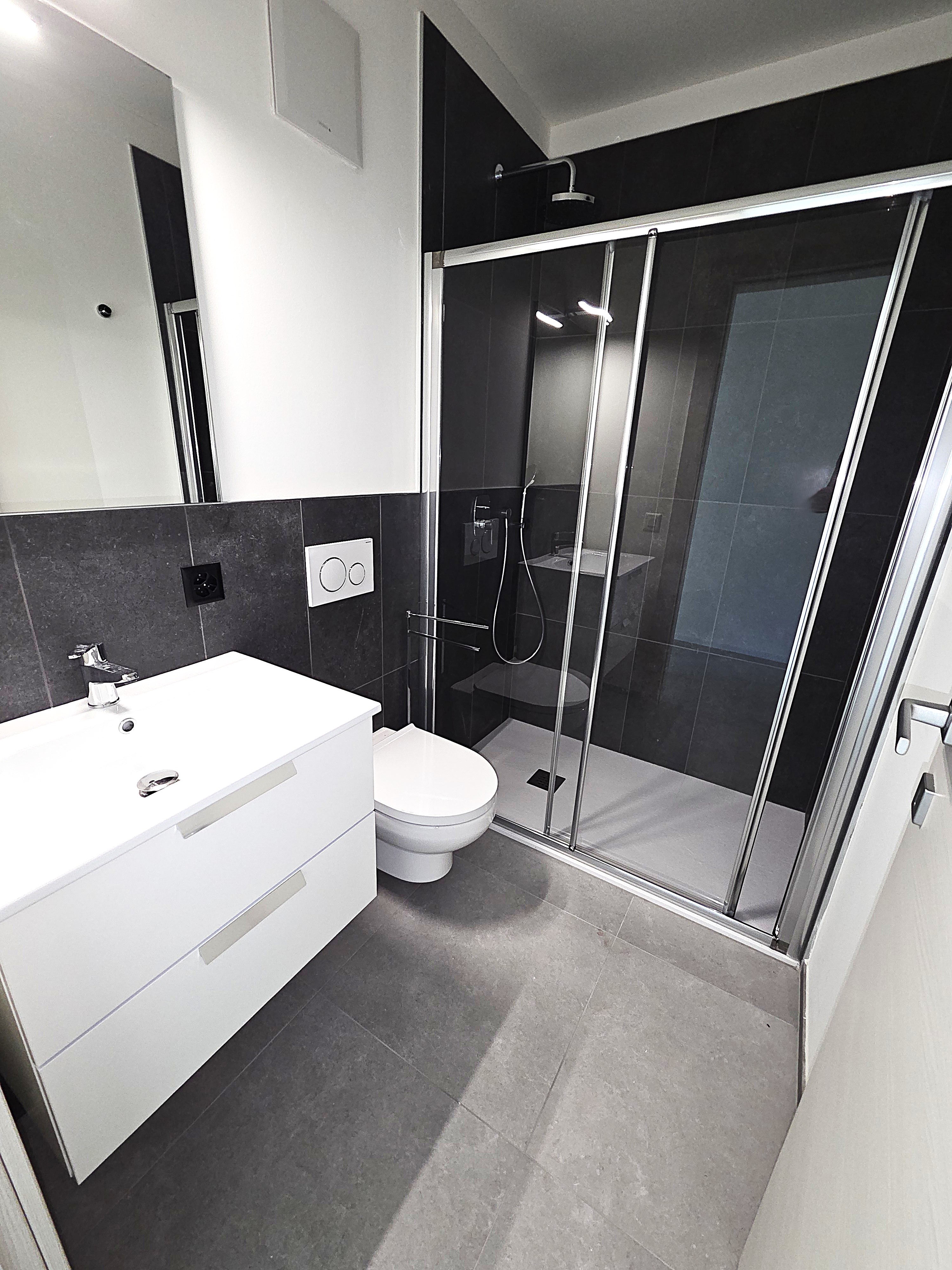 Modernes Badezimmer mit Dusche und weißem Waschtisch