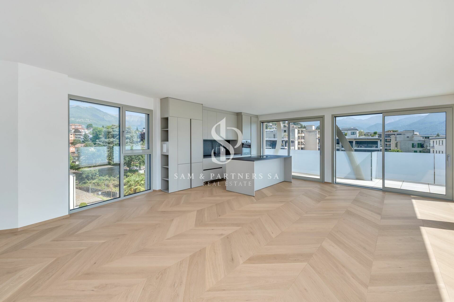 Offener Wohnraum mit Panoramafenstern und Einbauküche