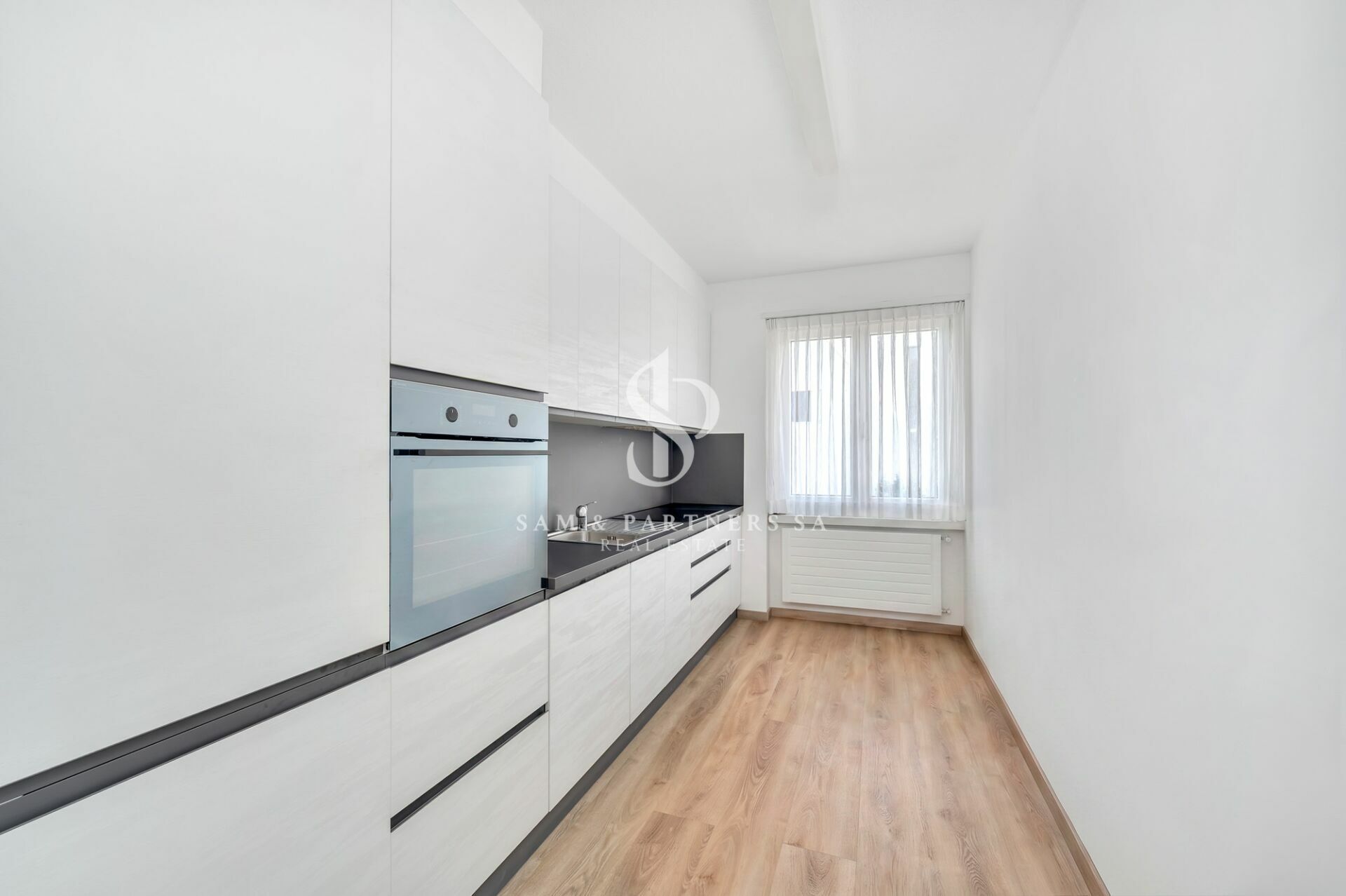 Schmale moderne Küche mit Fenster