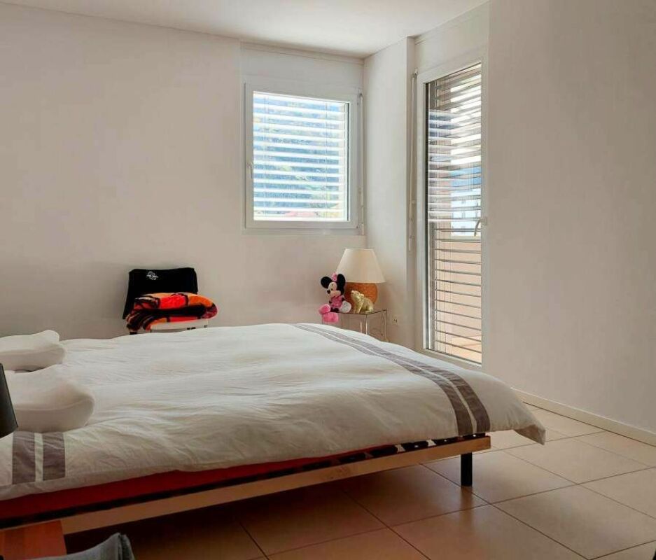 Helles Schlafzimmer mit großem Bett und bodentiefen Türen
