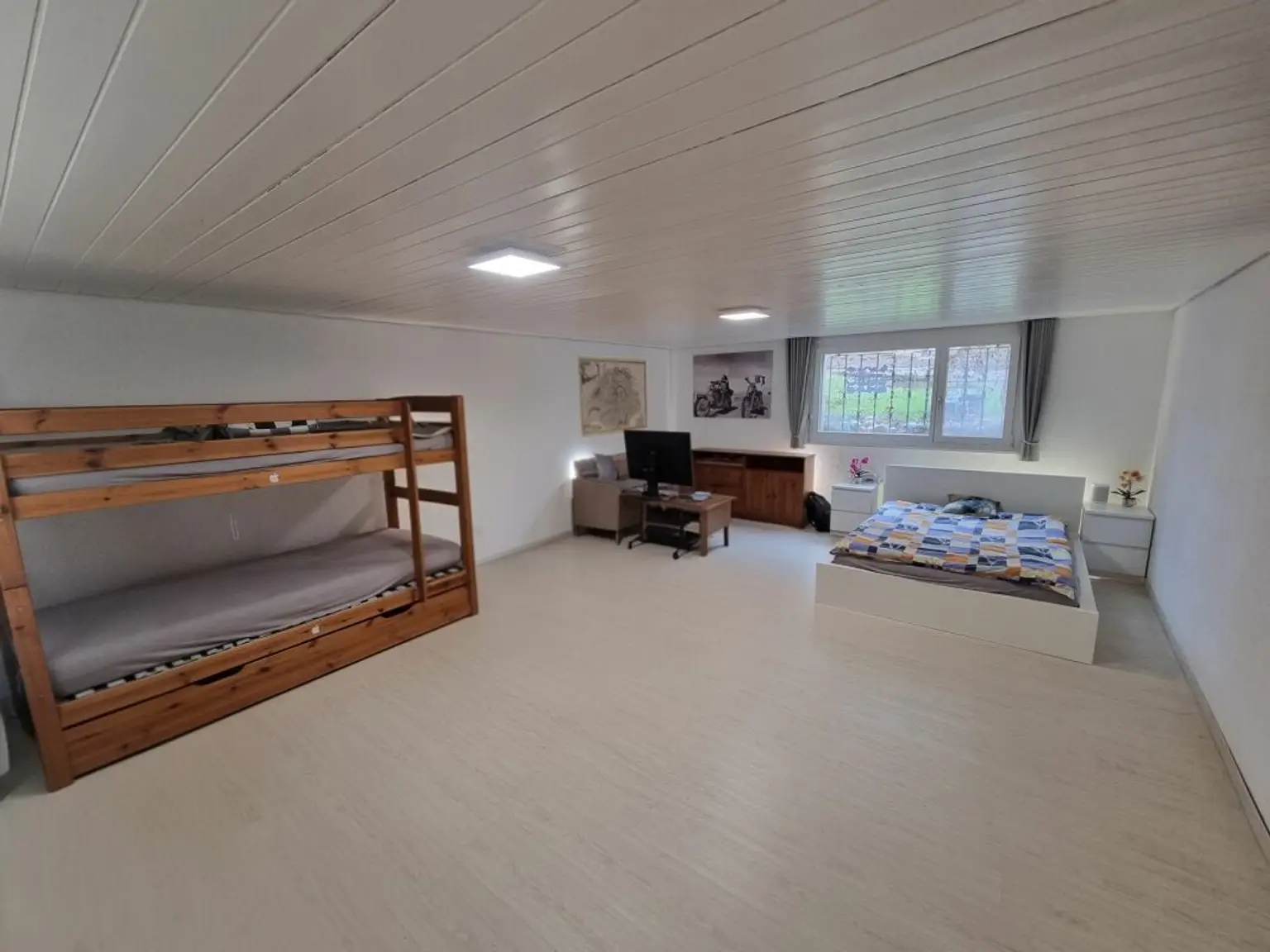 Helles Schlafzimmer mit Doppelstockbett und Einzelbett