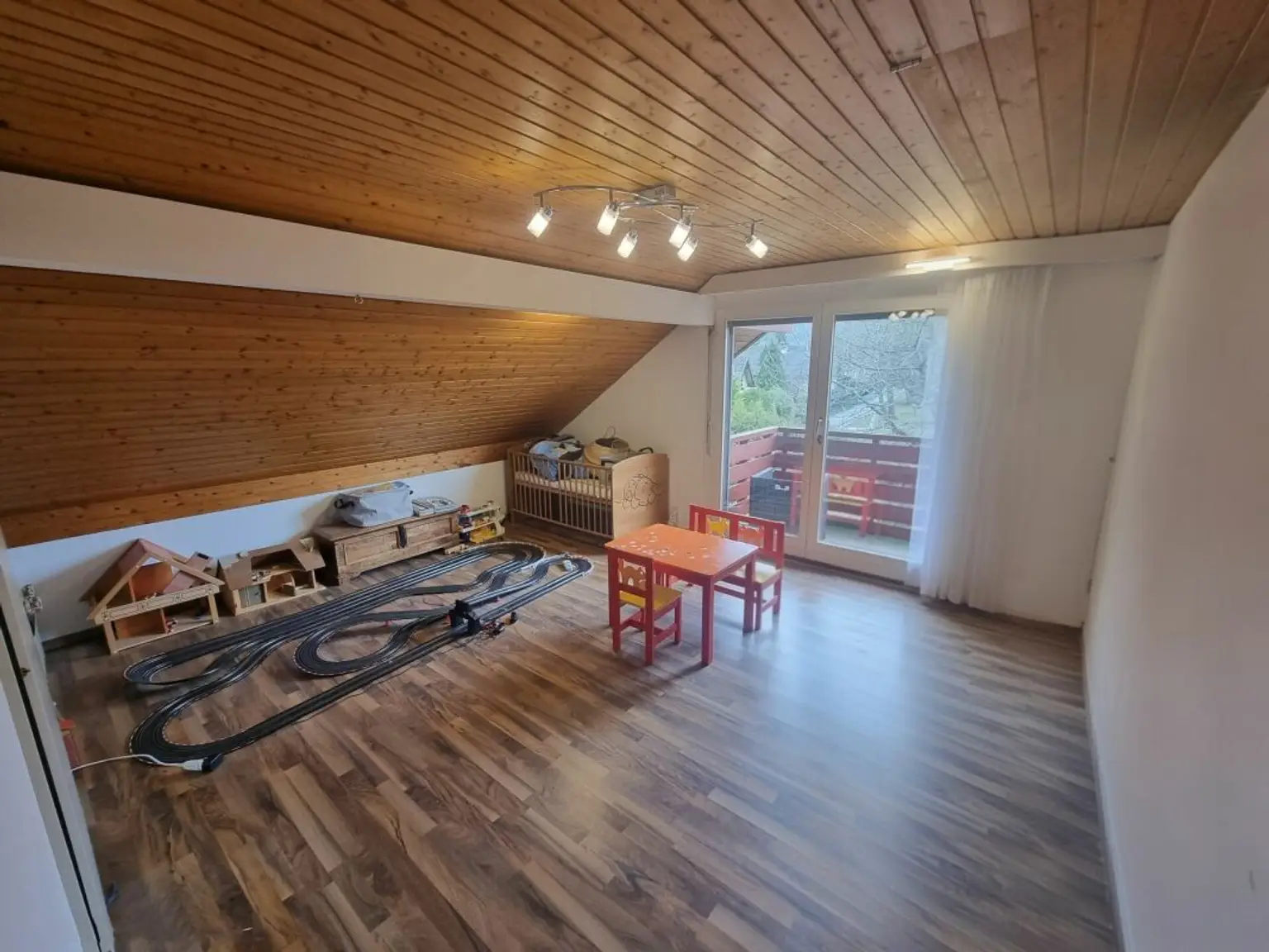 Dachgeschossraum mit Spielbereich und Balkon