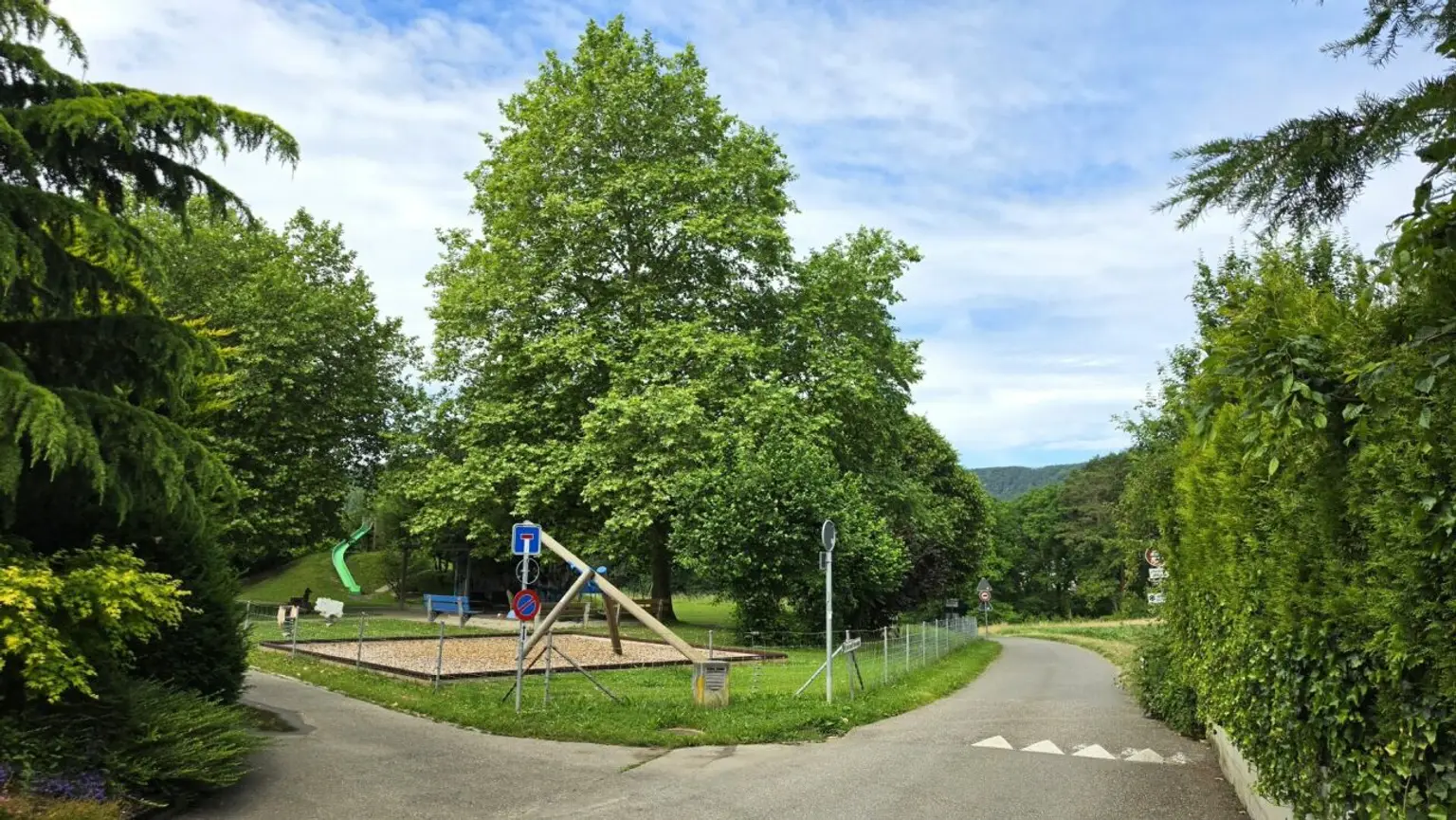 Parkähnliche Grünanlage mit Wegen und Spielbereich