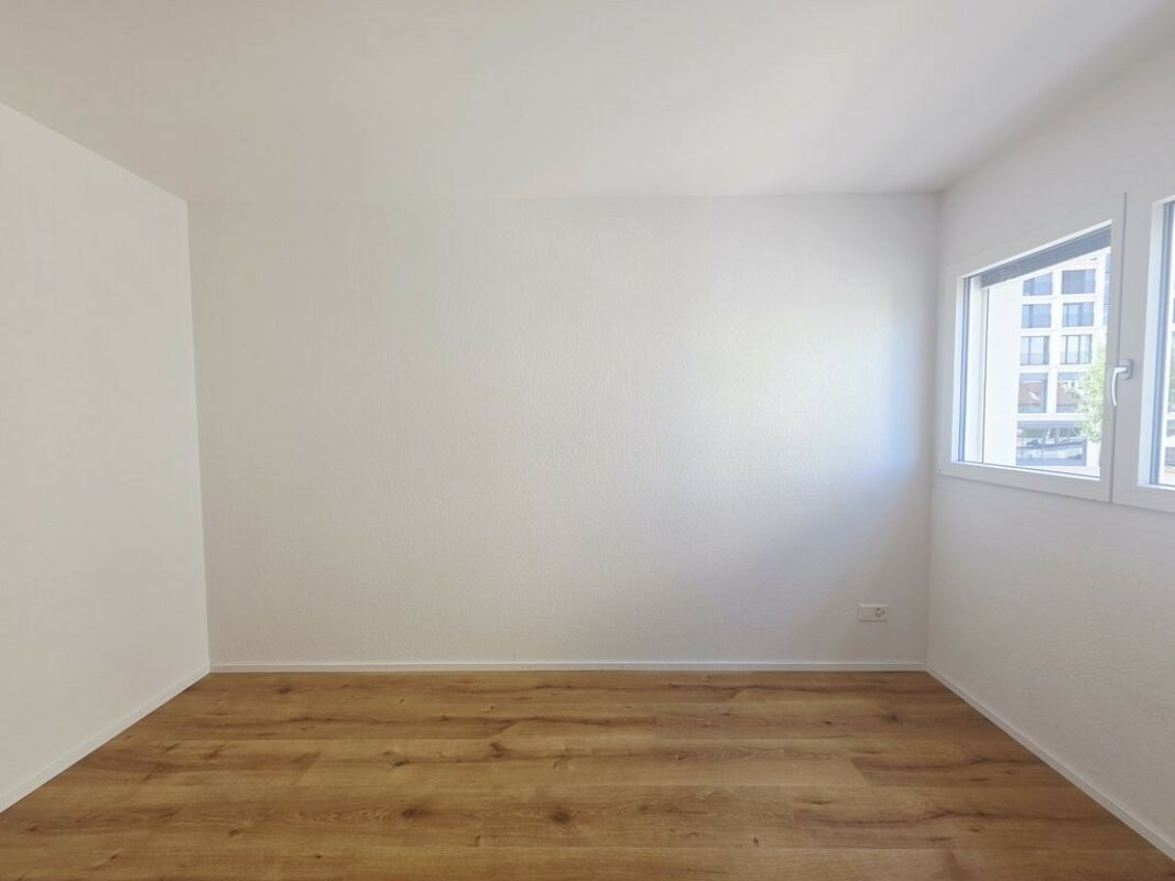 Leeres, helles Zimmer mit Holzoptikboden
