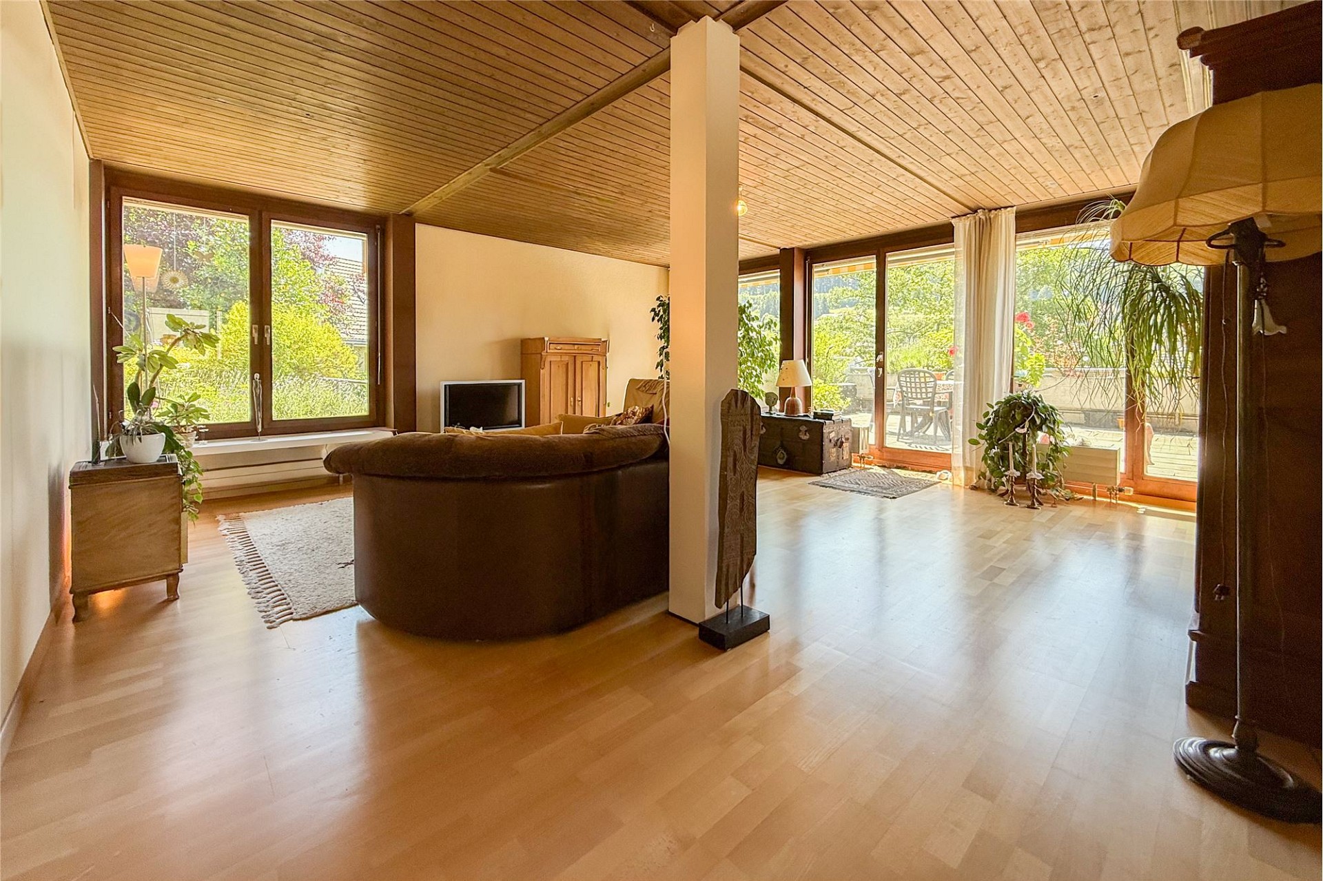 Helles Wohnzimmer mit Holzdecke und Terrasse