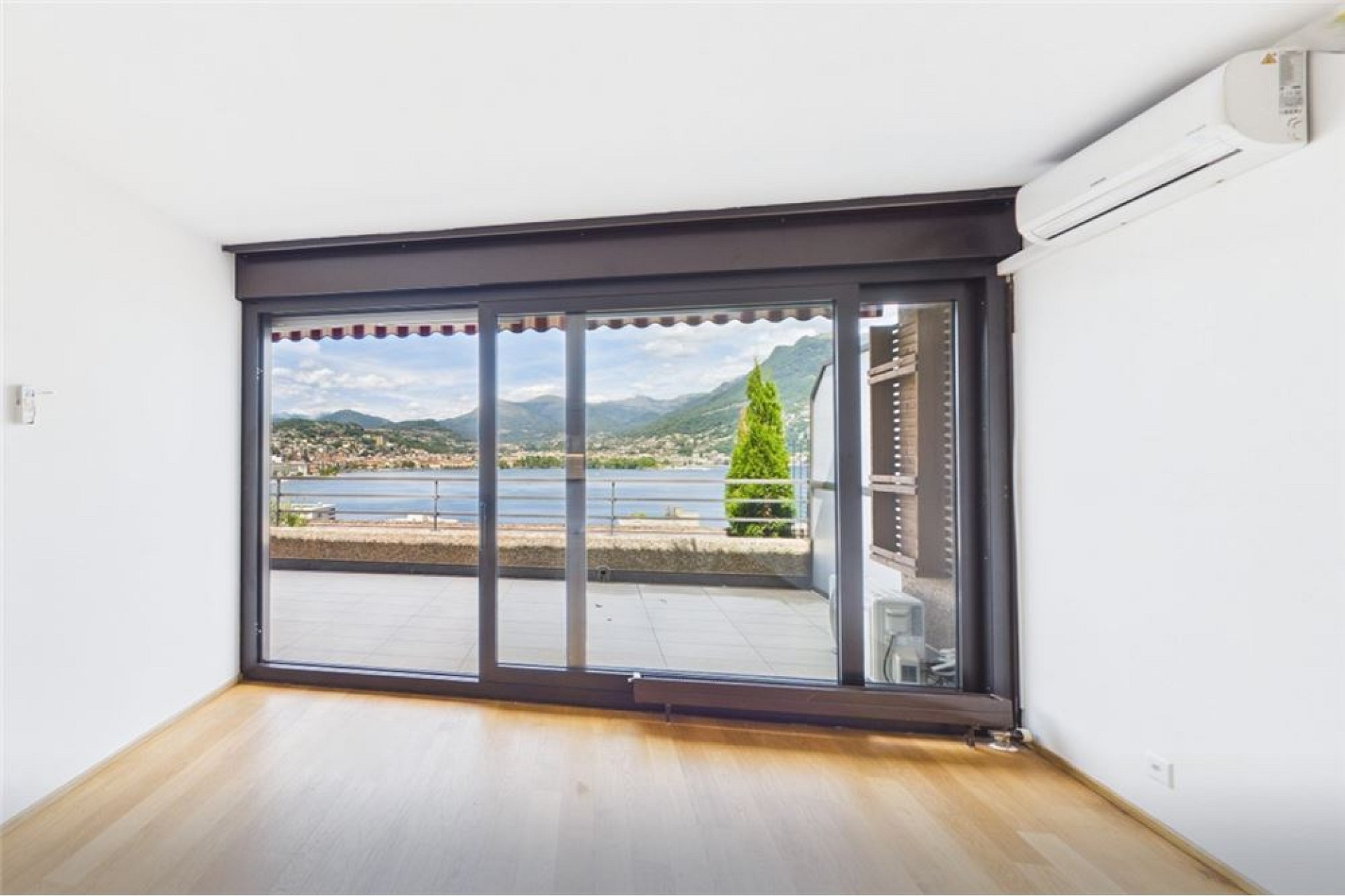 Heller Raum mit großem Panoramafenster und Seeblick