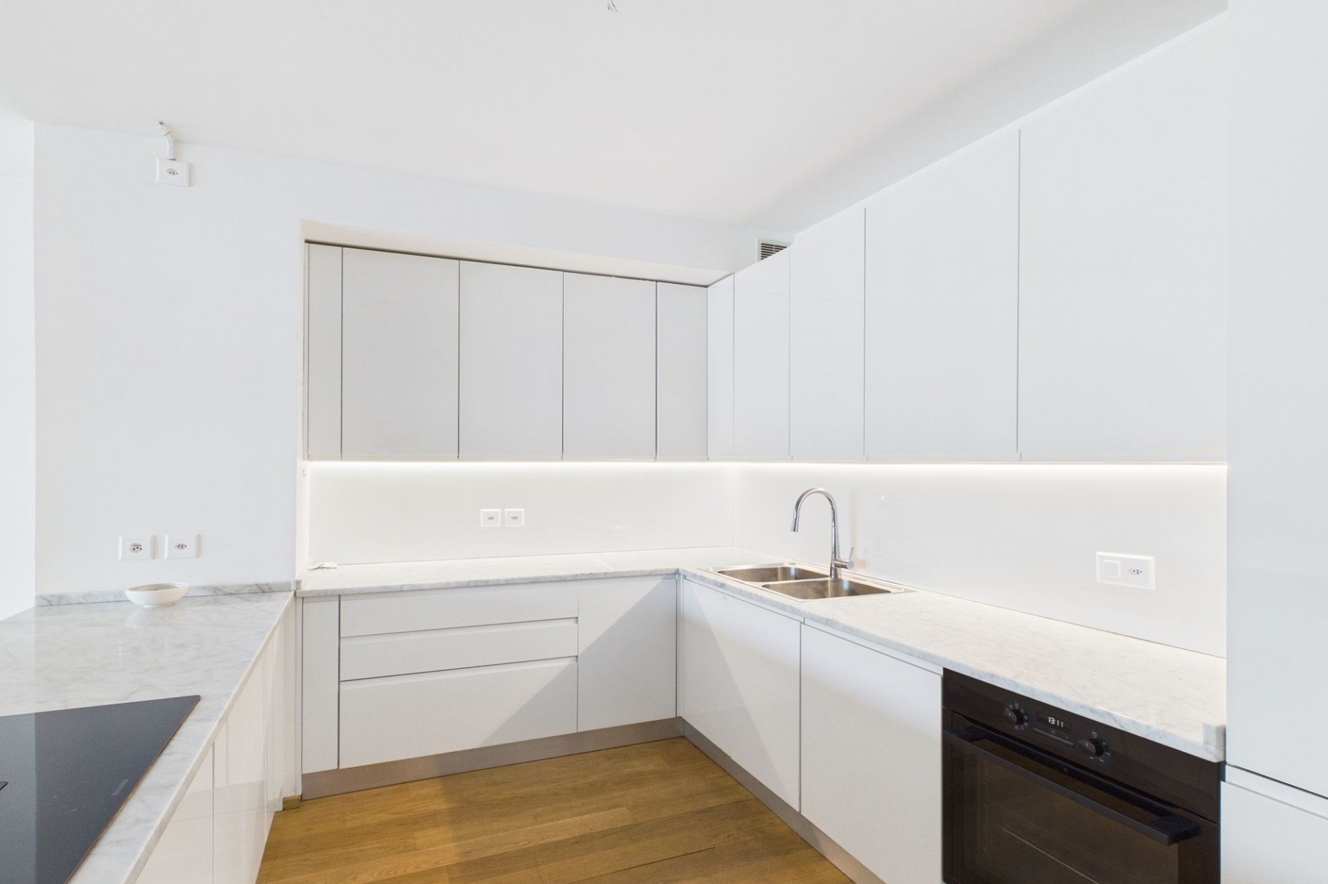 Moderne weiße Küche mit Holzfußboden