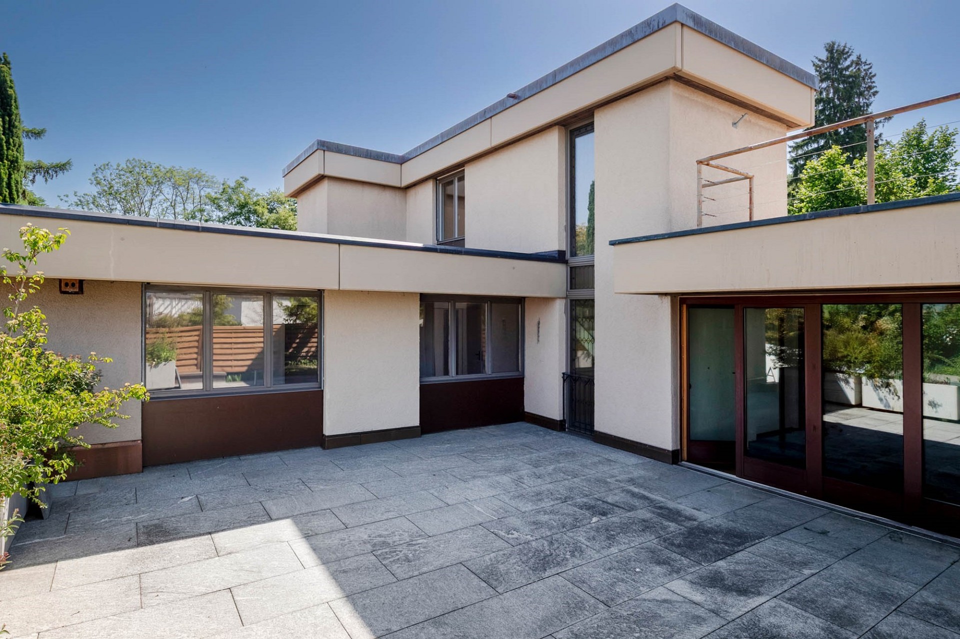 Moderne Patio-Terrasse mit Hausansicht