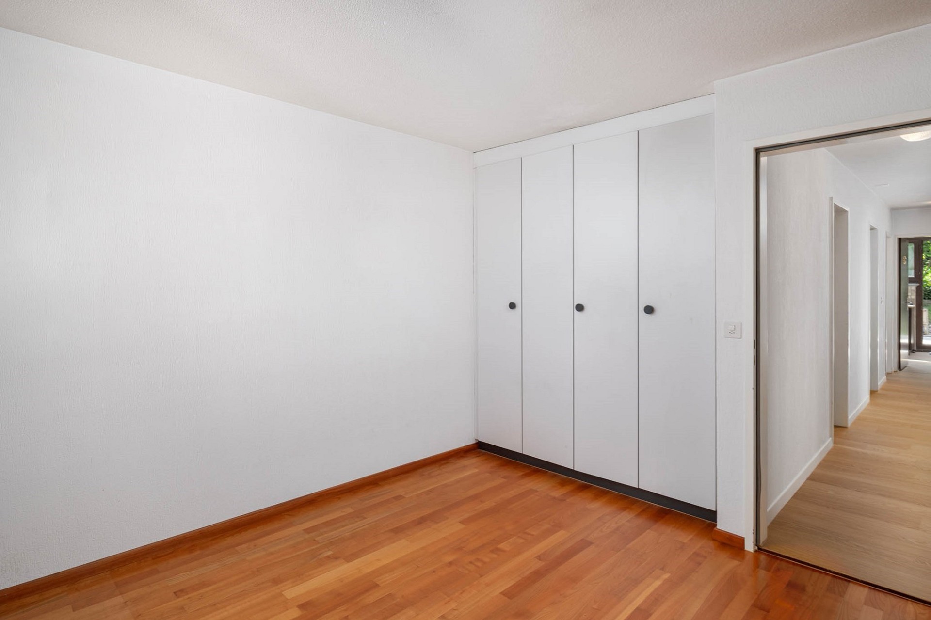 Heller leerer Raum mit Einbauschrank und Blick in den Flur