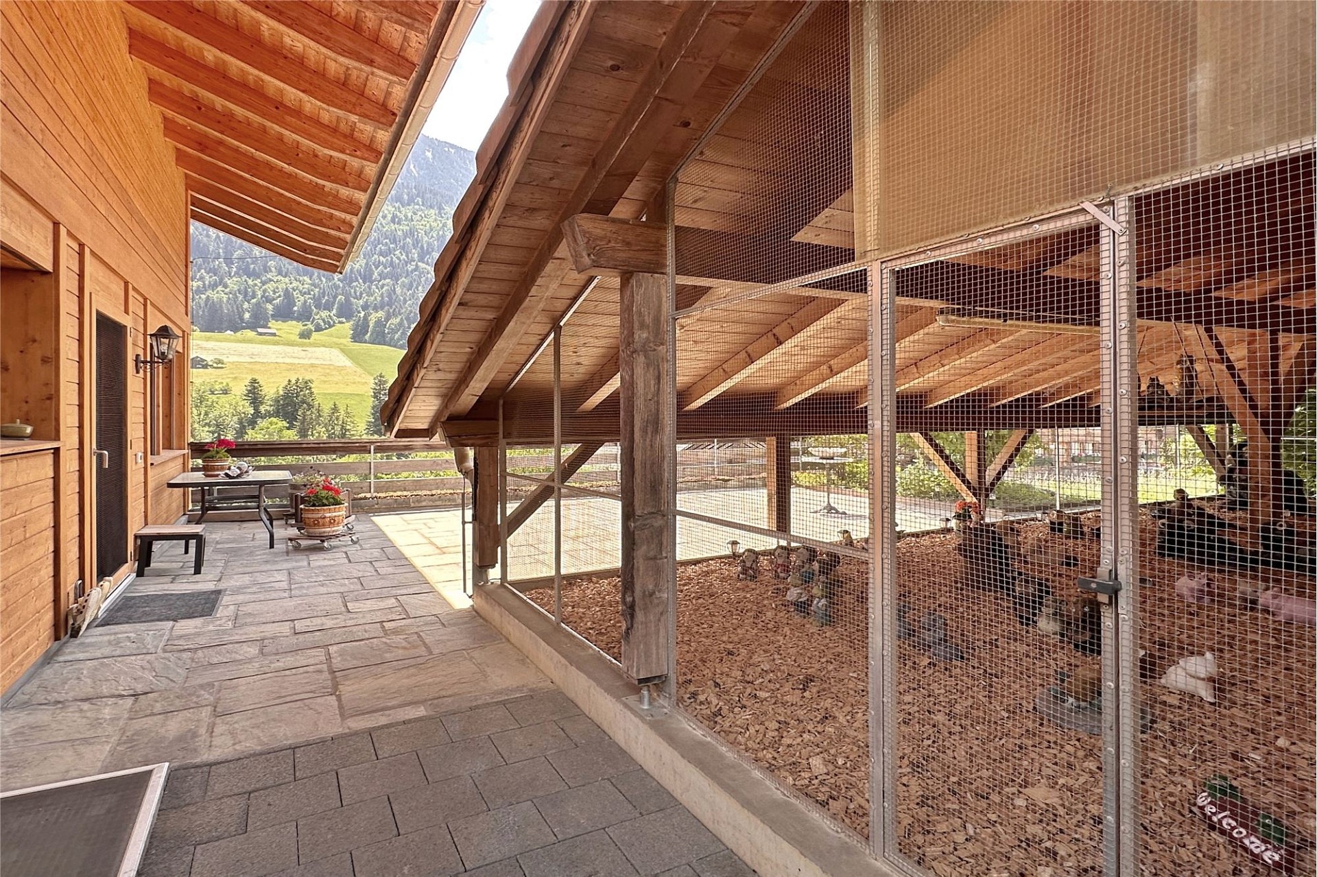 Bergblick von einer Holzterrasse mit Tiergehege
