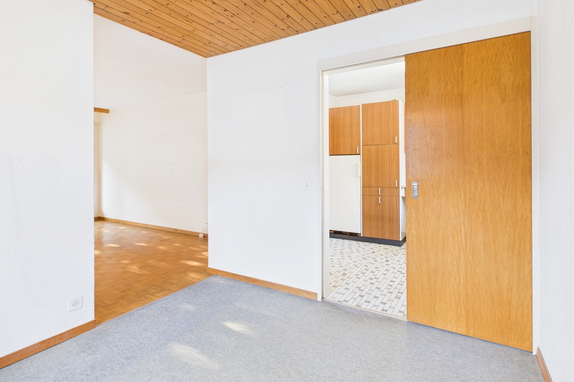 Heller Innenraum mit Holzdecke und Schiebetür