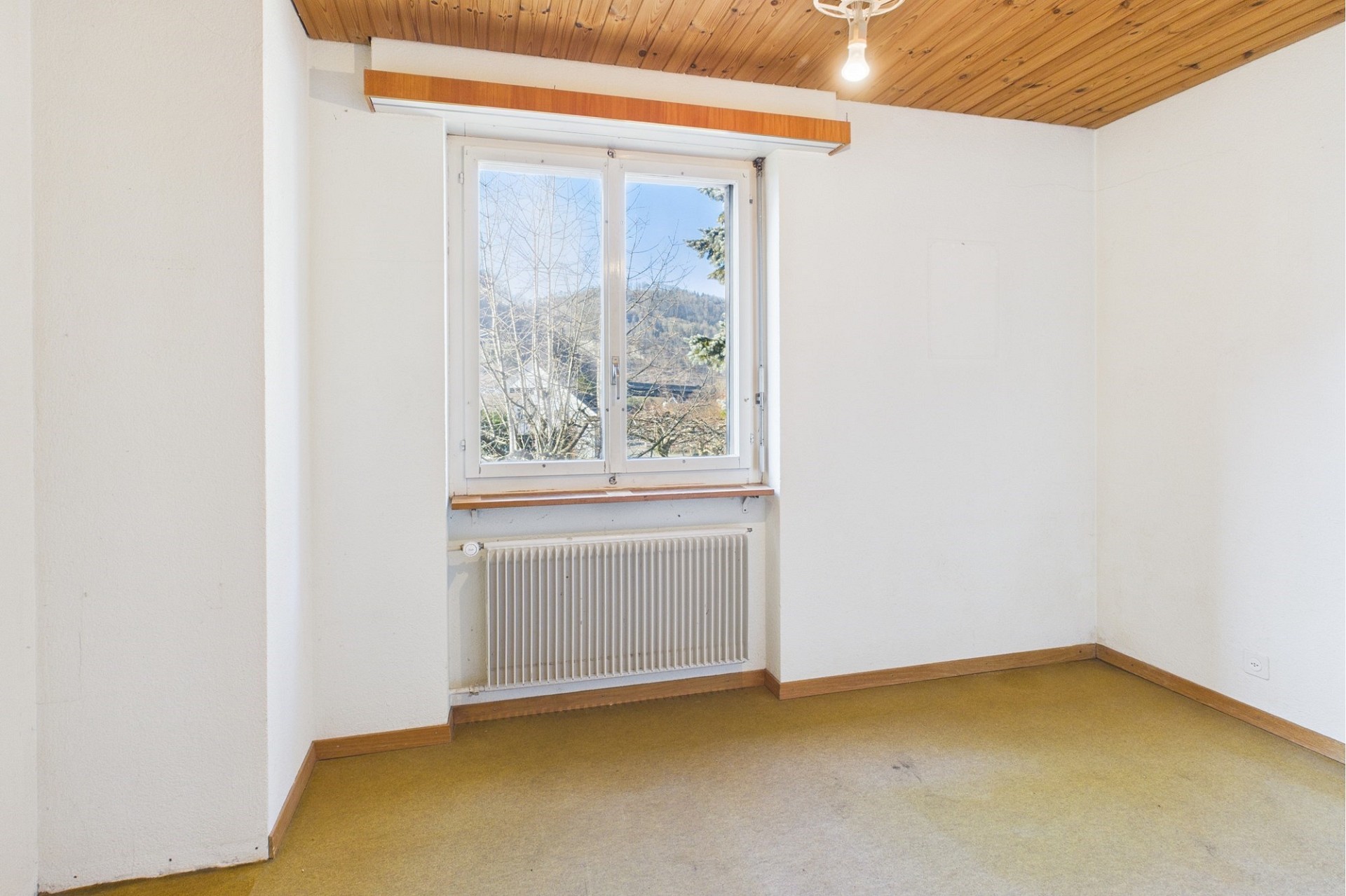 Leeres Zimmer mit Fenster und Heizkörper