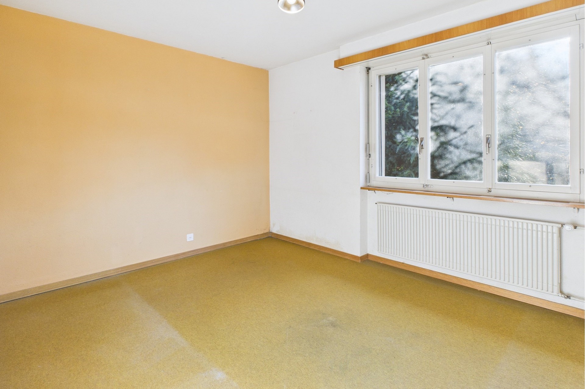Leeres Zimmer mit Fenster und Heizkörper