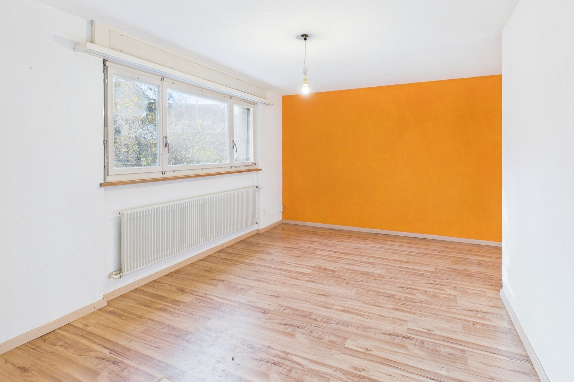 Heller leerer Raum mit orangefarbener Akzentwand