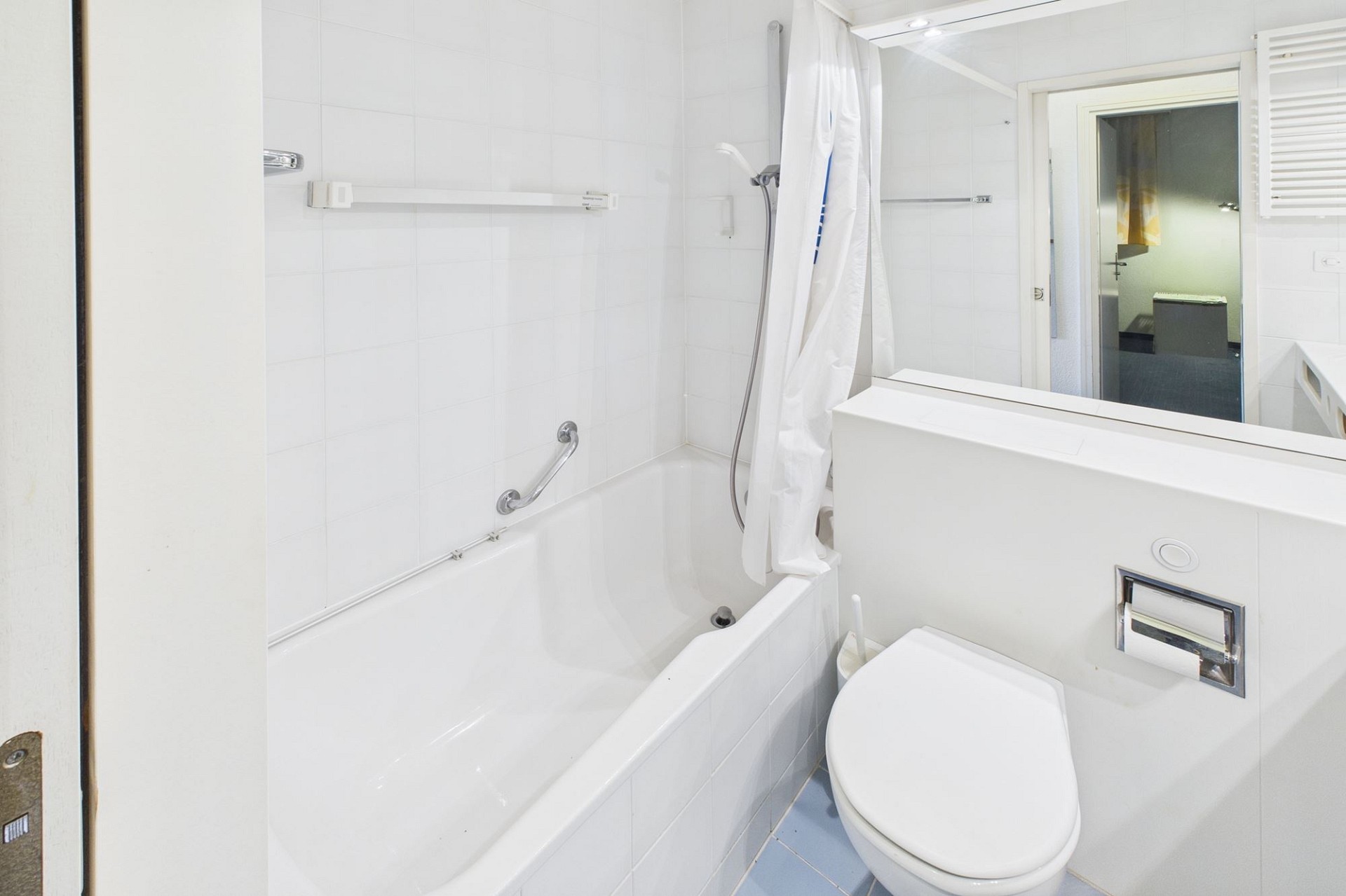 Kleines weißes Bad mit Wanne und WC
