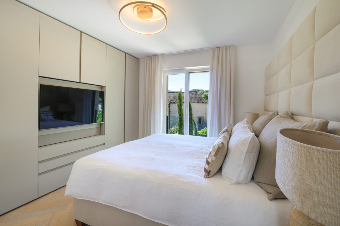 Helles Schlafzimmer mit Einbauschrank und Fensterblick